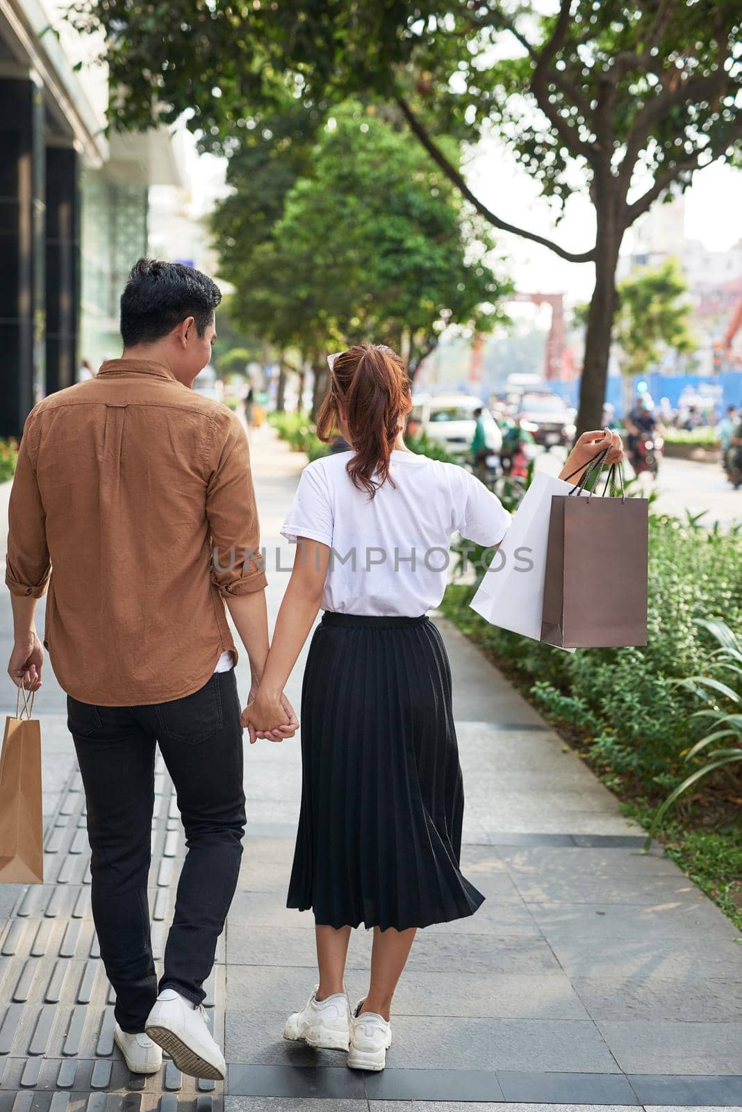 Young happy couple with shopping bags in the city.  by makidotvn