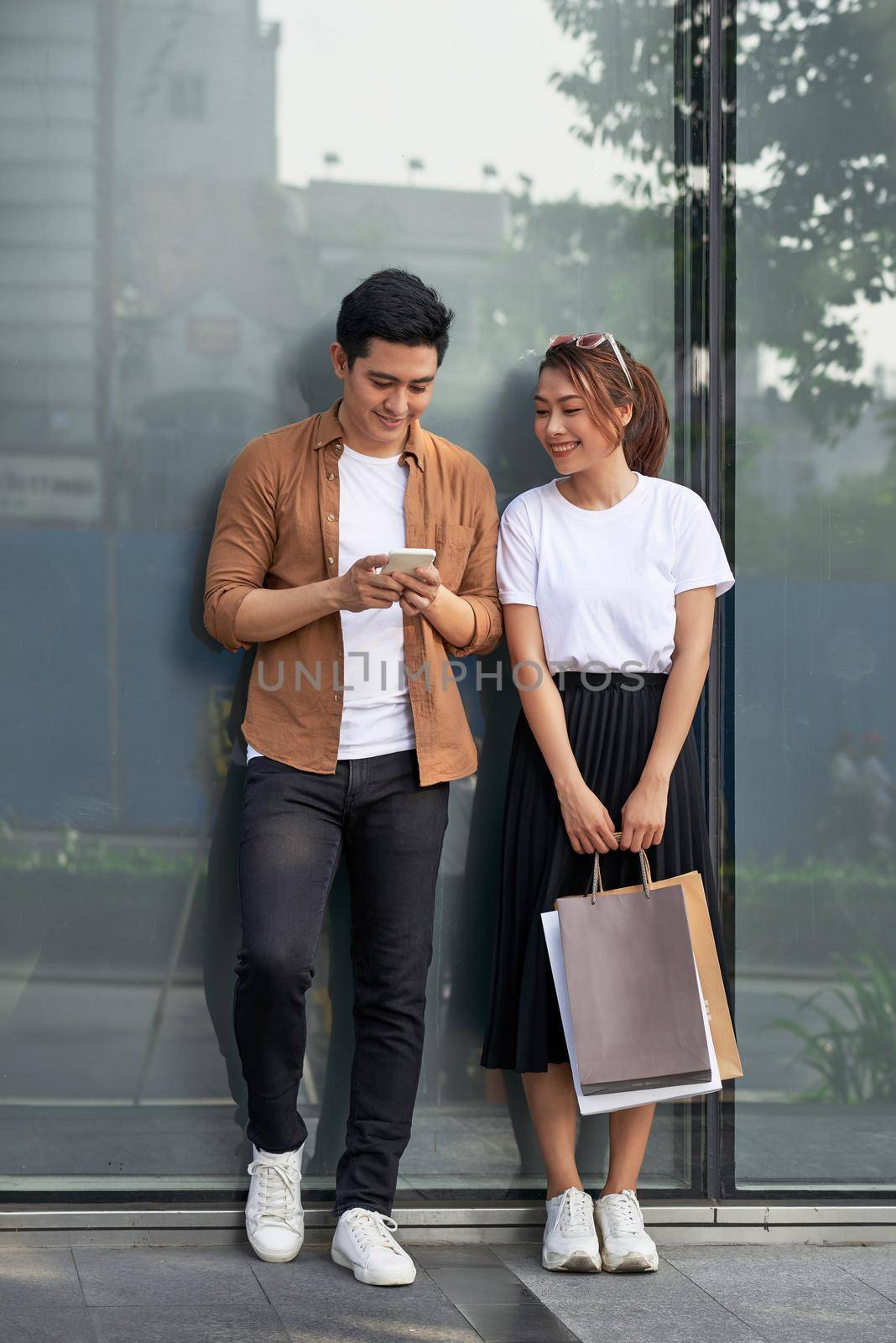 A picture of a couple shopping with smartphone in the city 