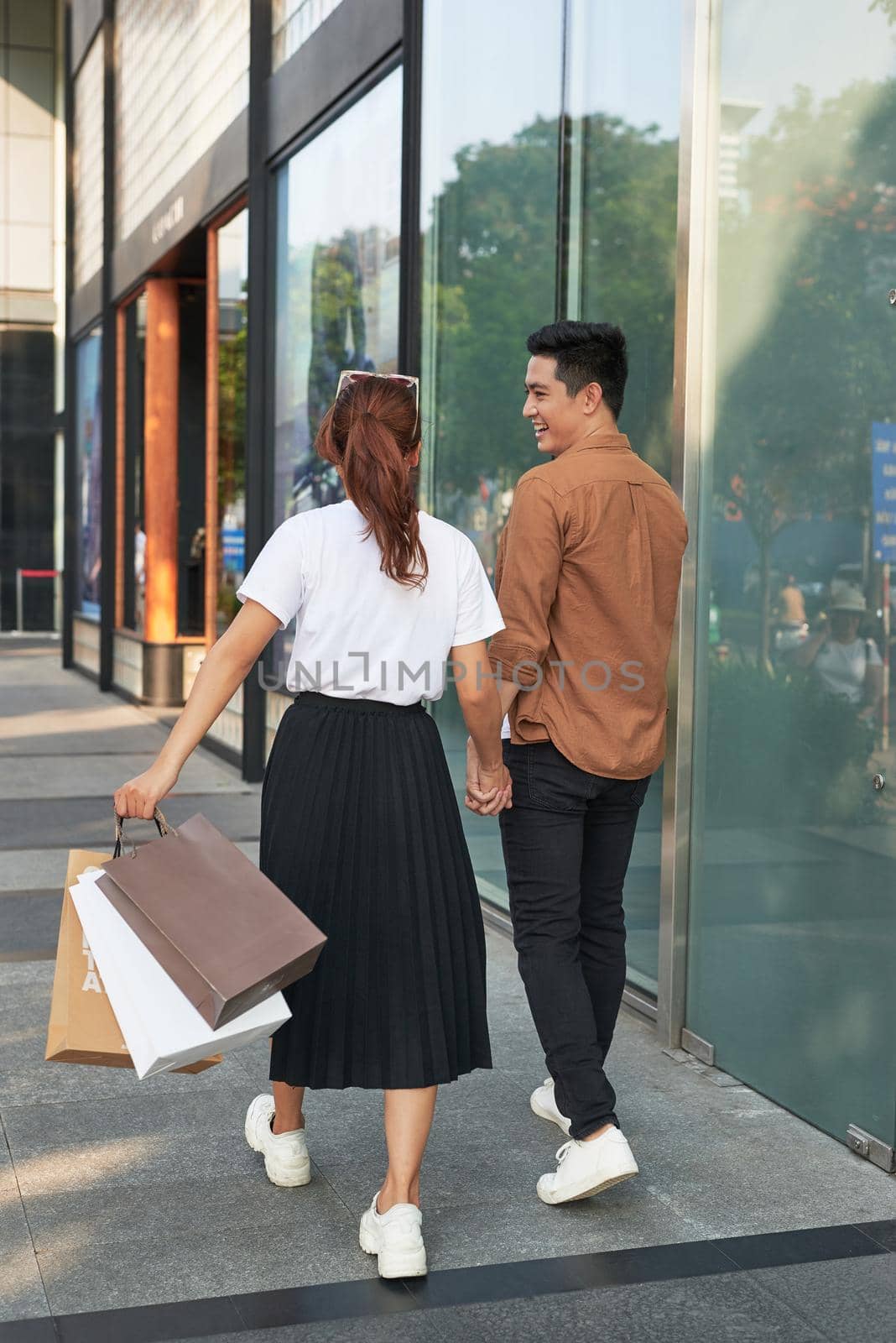 Young happy couple with shopping bags in the city,having fun together by makidotvn
