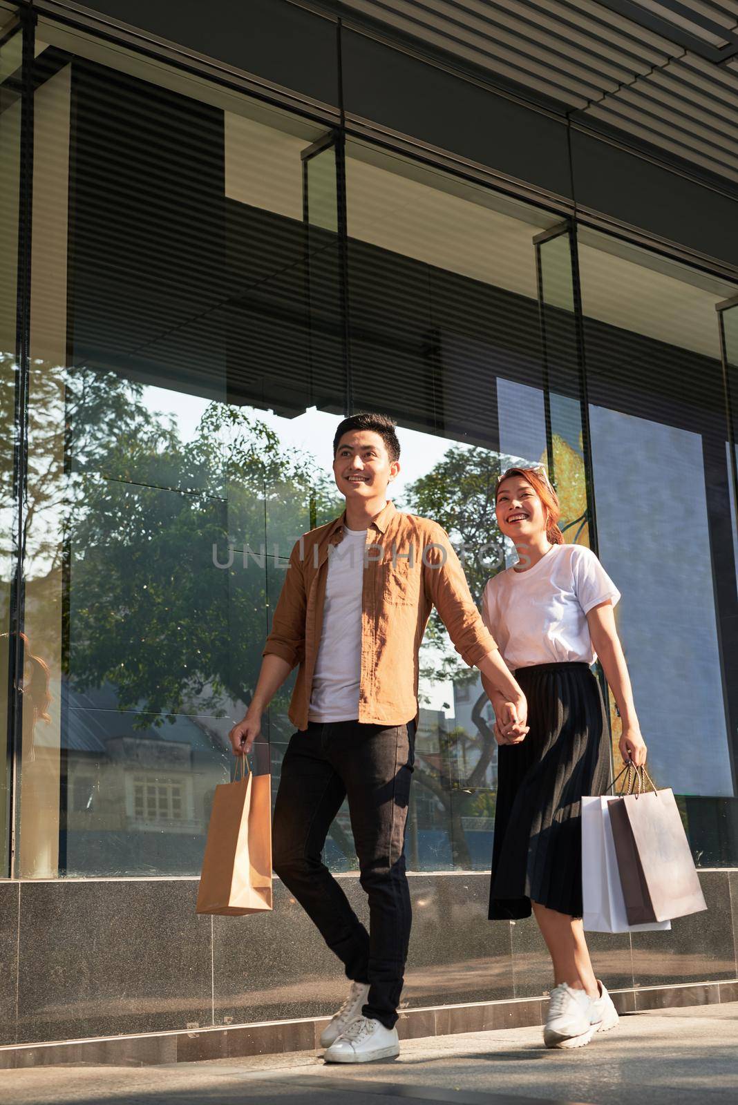 Young happy couple with shopping bags in the city.  by makidotvn