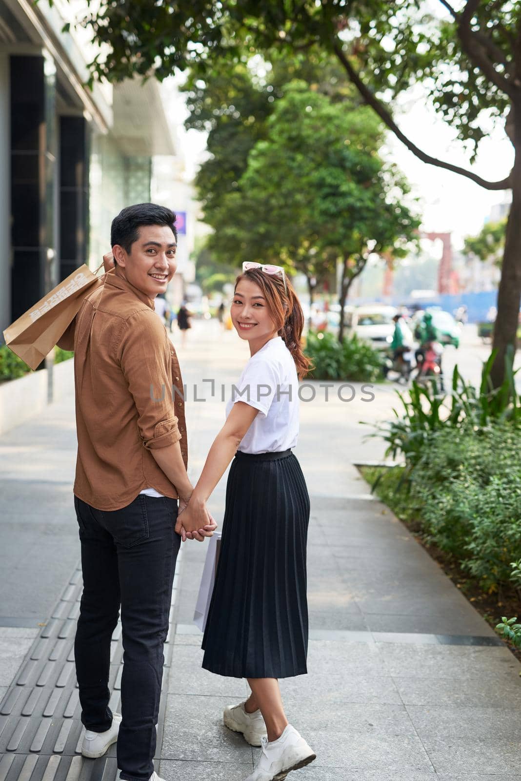 Young happy couple with shopping bags in the city. 