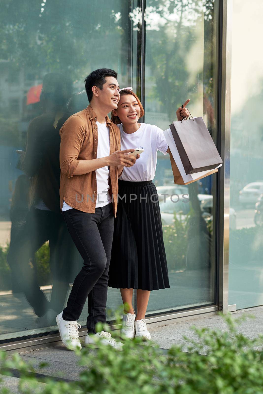 A picture of a couple shopping with smartphone in the city 