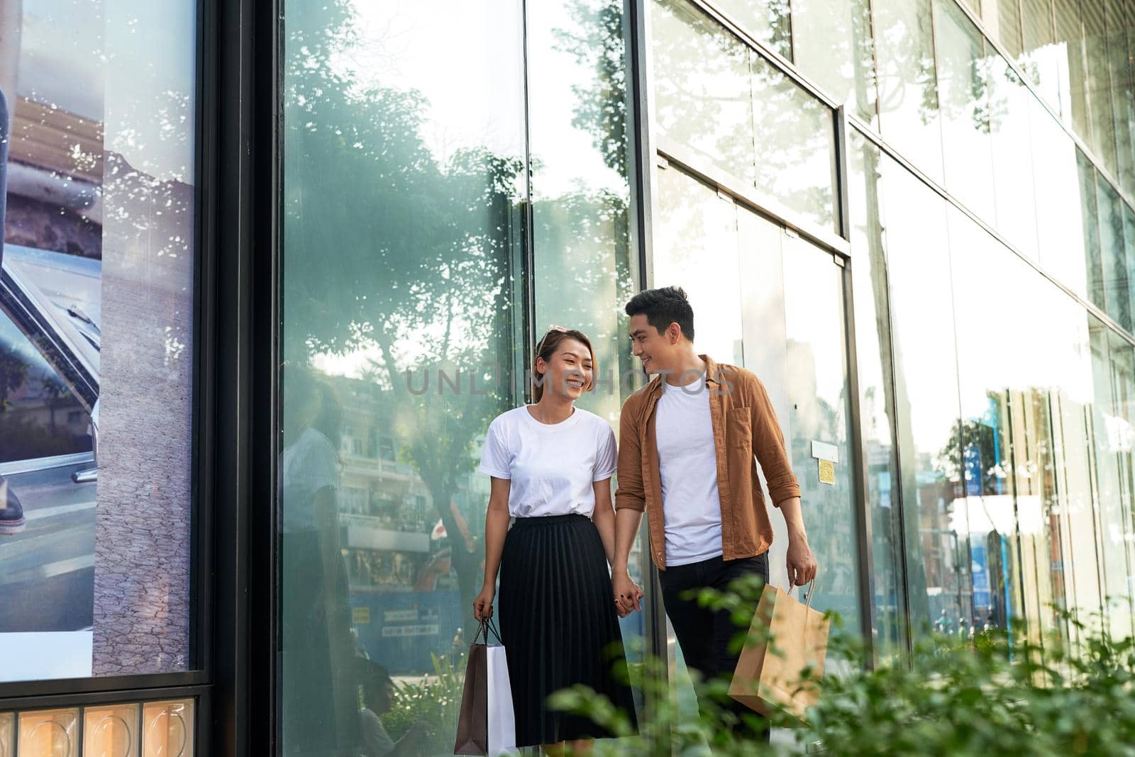 Young happy couple with shopping bags in the city. by makidotvn