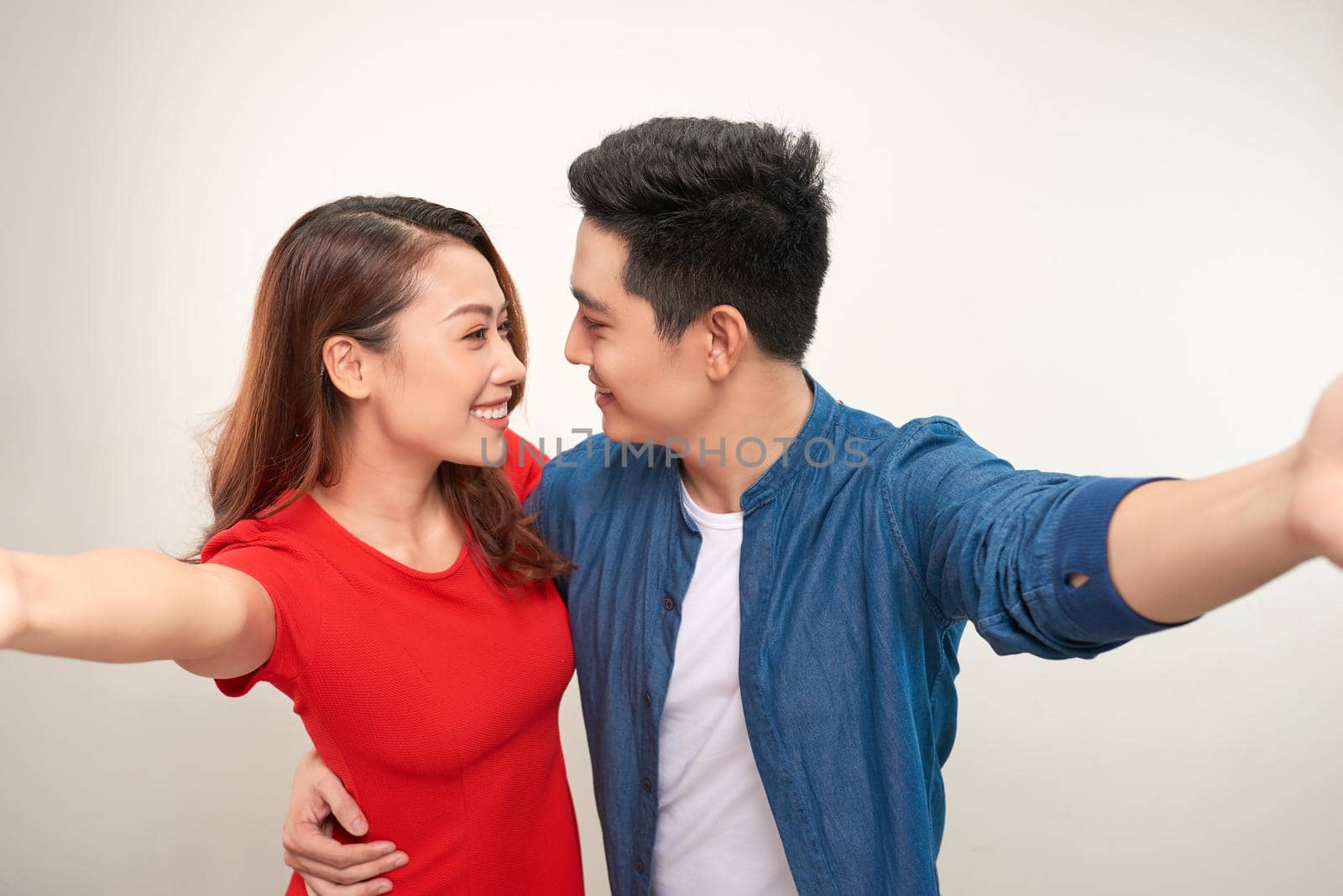 Young couple take selfie on white background