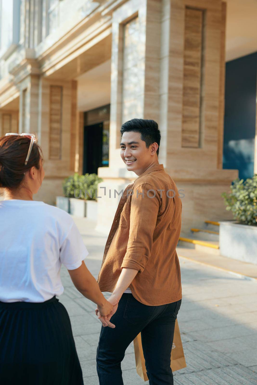 Couple with shopping bags holding hands at shopping mall