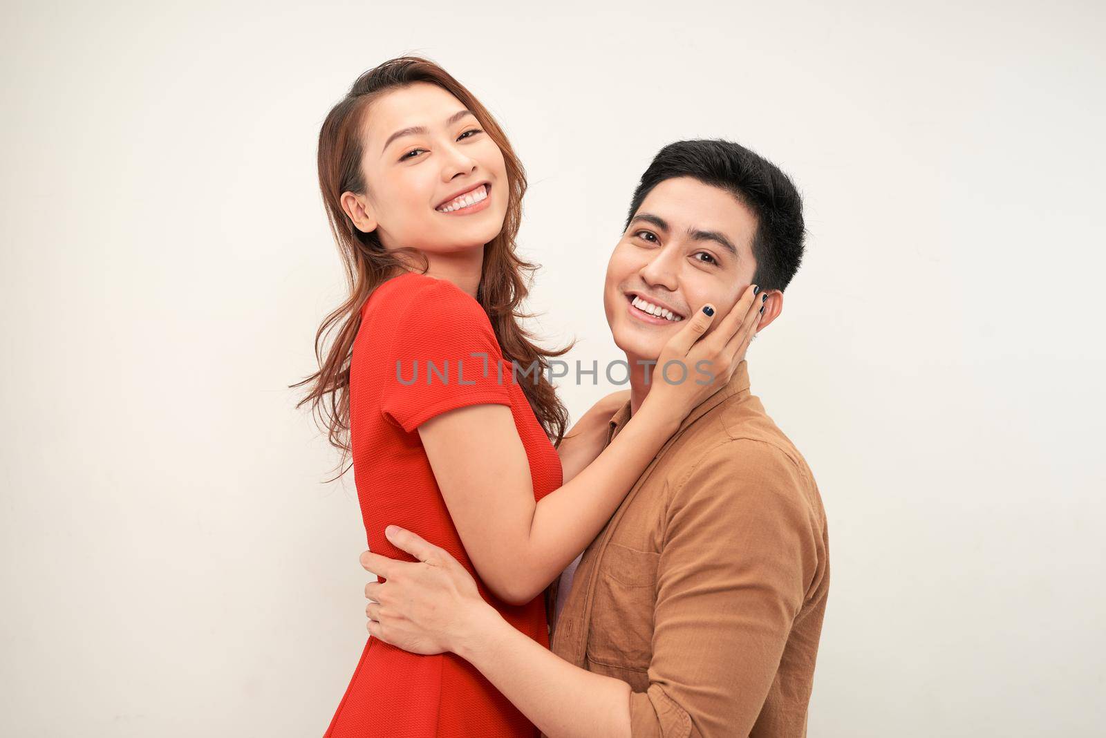 Handsome man picking up and hugging his girlfriend isolated on white background