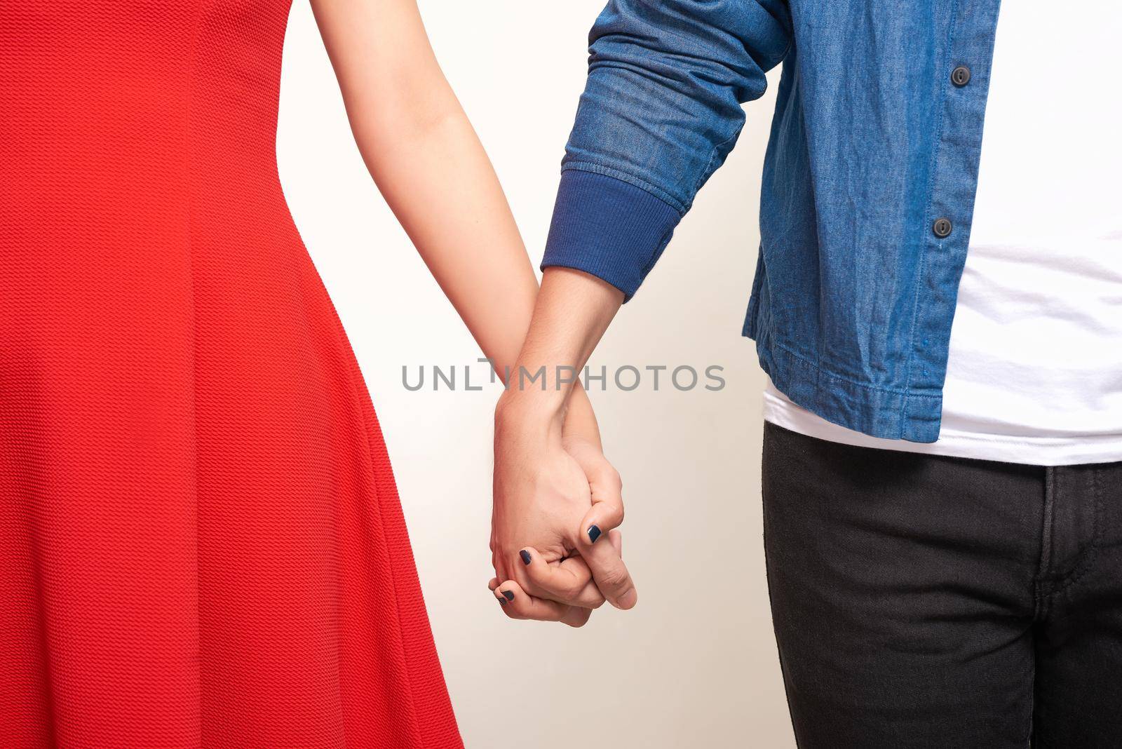 Close up of a couple holding hands over white background