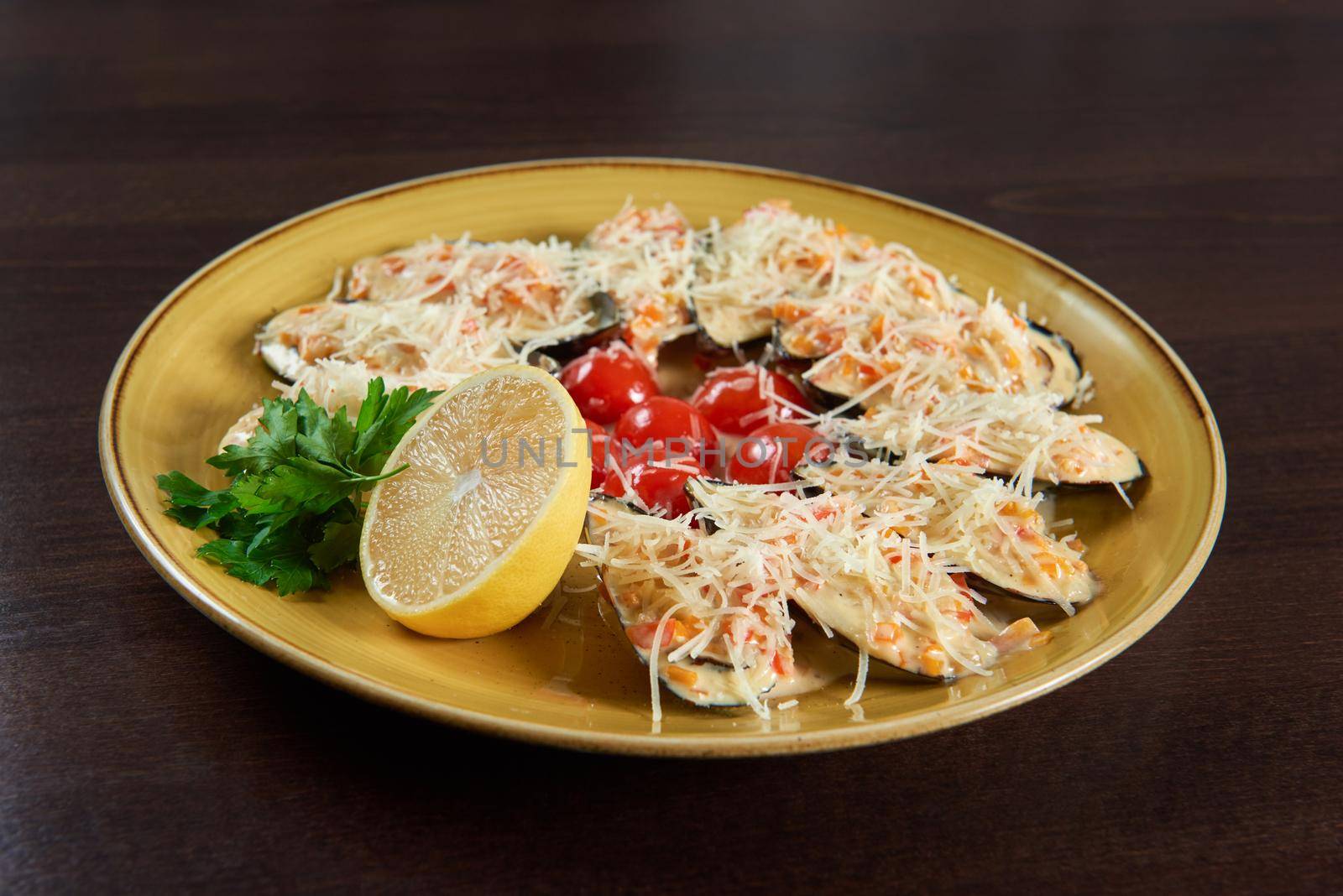 Seafood and cheese. Closeup top view shot of shellfish mussels baked with cream cheese sauce on a plate at the restaurant