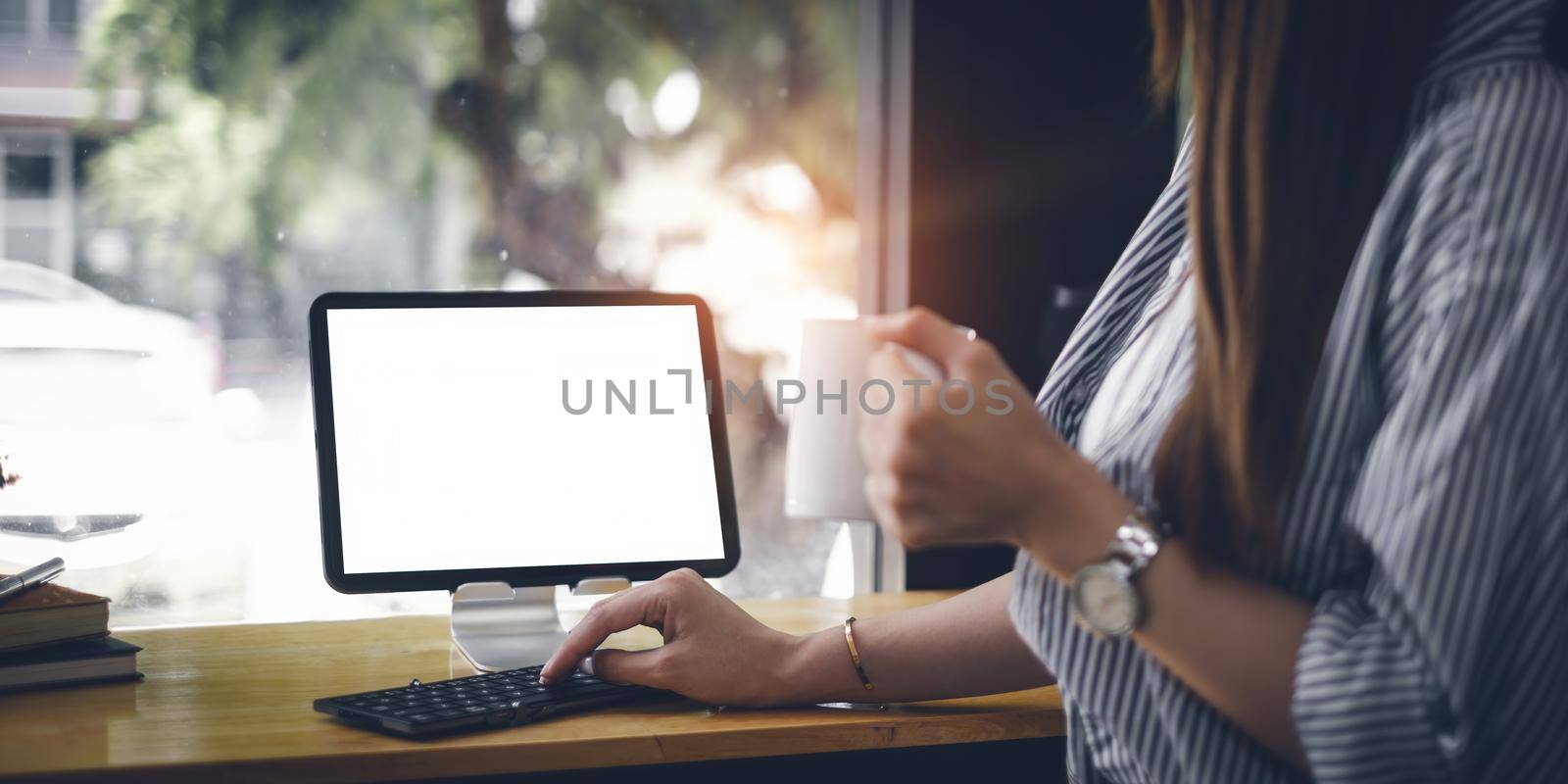 Mockup image of a black tablet with white blank screen on wooden desk by itchaznong