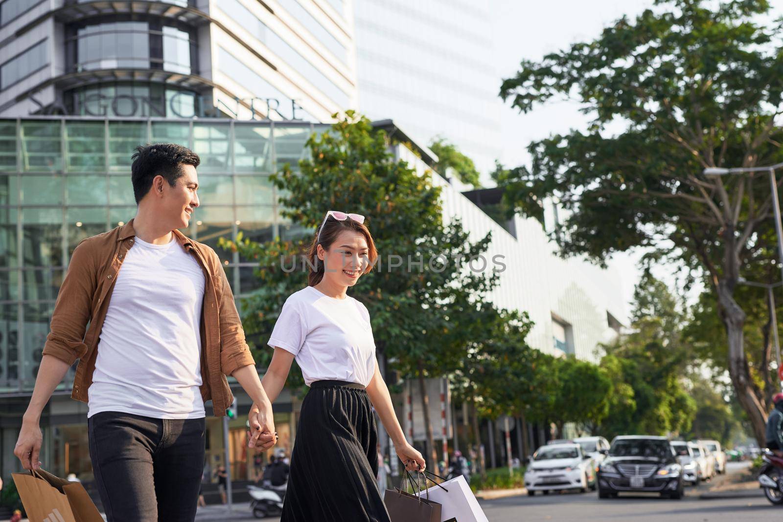 Young Asian couple going out for shopping on Le Loi road in Hochiminh city, Vietnam
