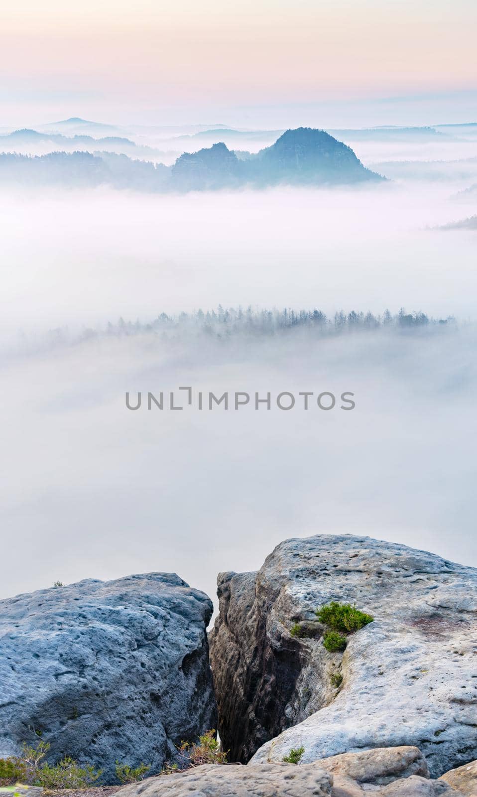 Mountain top rock, sleepy misty landscape bellow under morning mist. by rdonar2