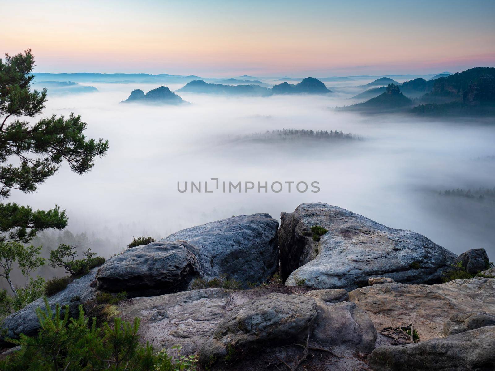 The fabulous vistas of Saxon Switzerland.  Kleiner Winterberg view, beautiful morning view over sandstone cliff into deep misty valley.