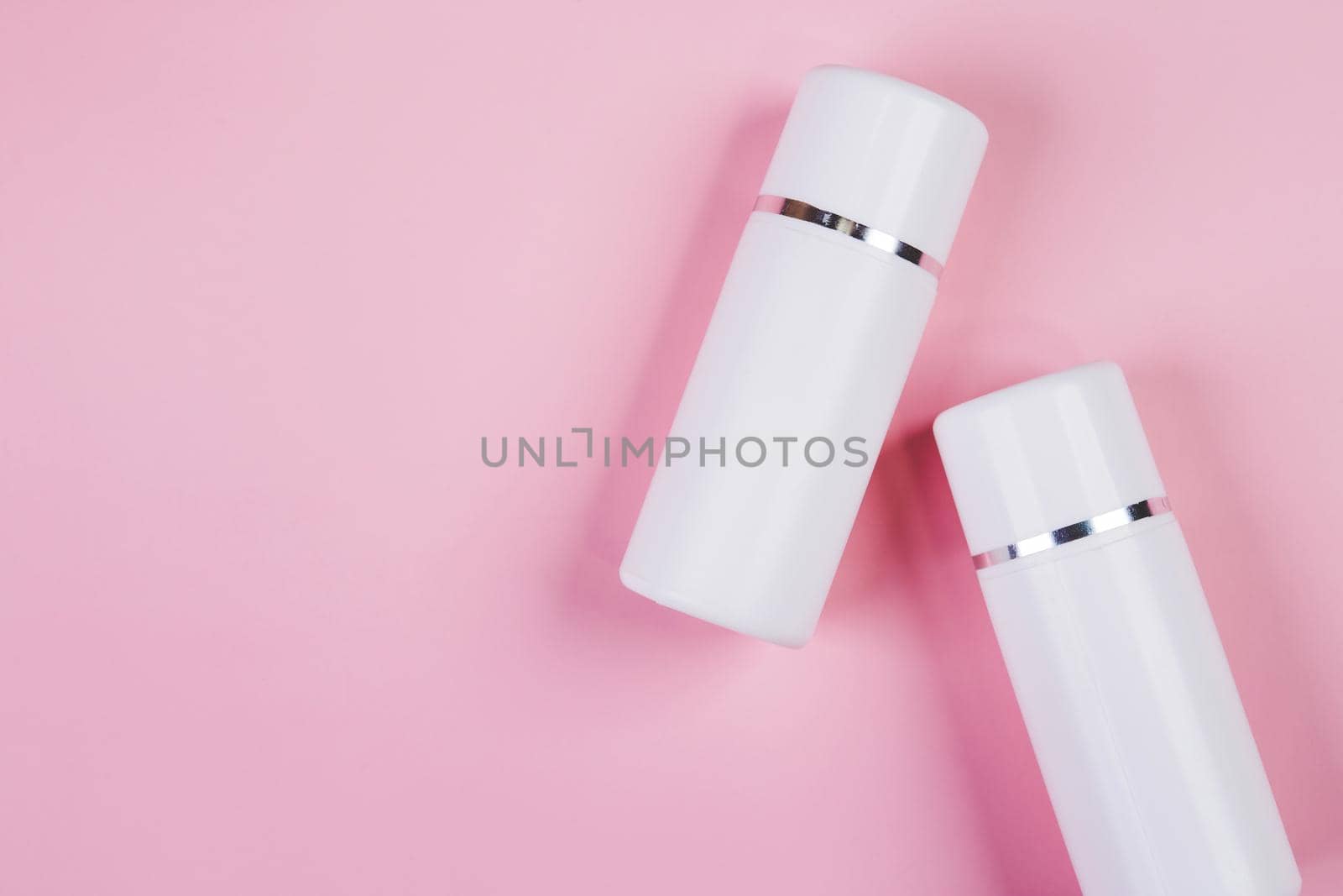 Mockup cosmetic bottle with cream or lotion isolated on pink background, mock up package for advertising, skincare or cosmetology, top view, flat lay, skin care and treatment with product.