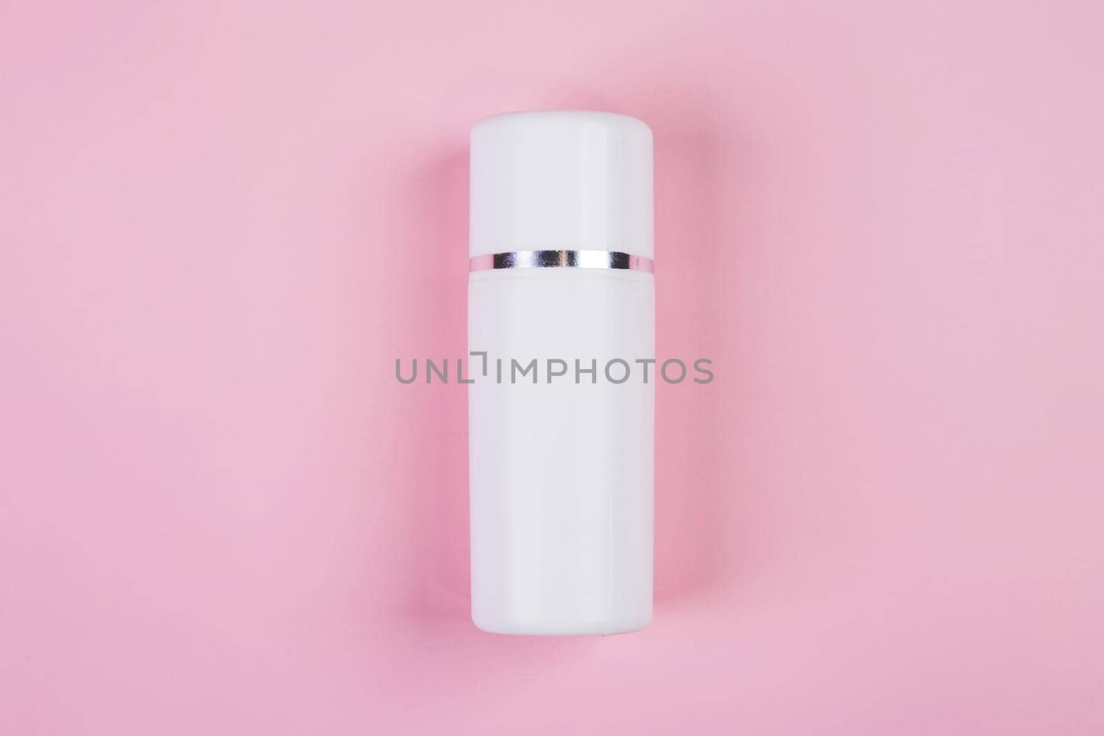 Mockup cosmetic bottle with cream or lotion isolated on pink background, mock up package for advertising, skincare or cosmetology, top view, flat lay, skin care and treatment with product.