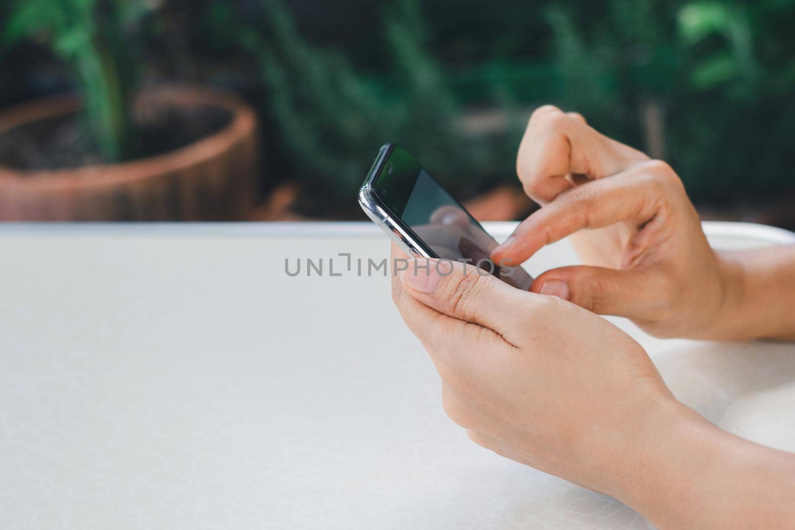 Woman's hand is using a smart phone to search for information online. by wattanaphob