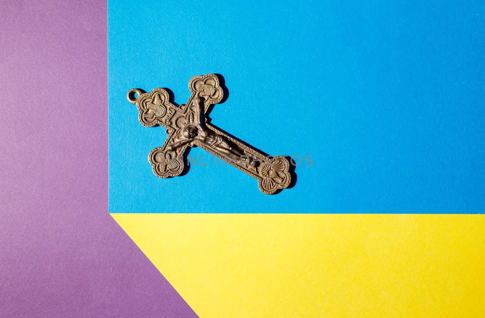 bronze cross on the colored table indoor closeup