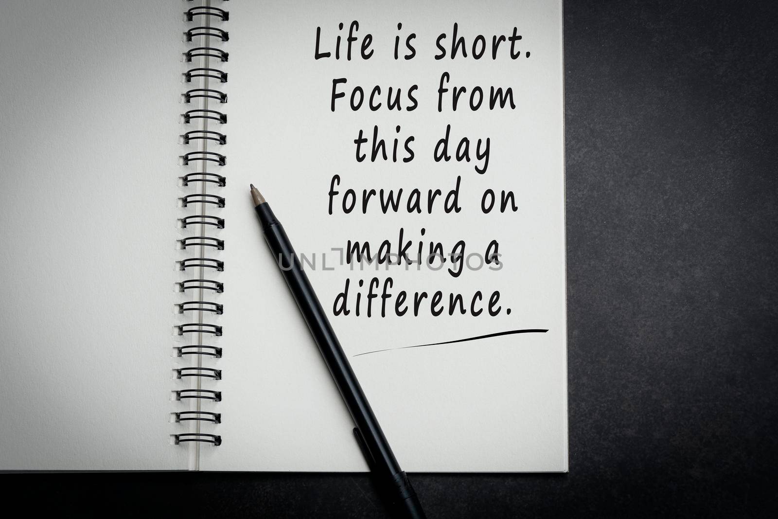 Motivational and inspirational quote on notebook with dark background
