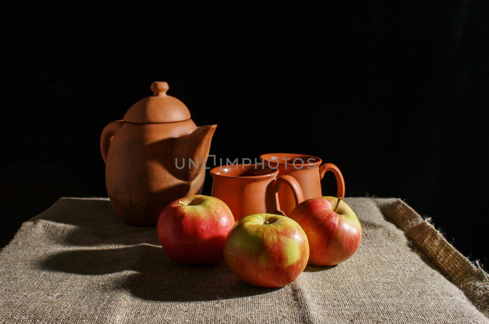 still life with a clay teapot, two cups and three red apples by raddnatt