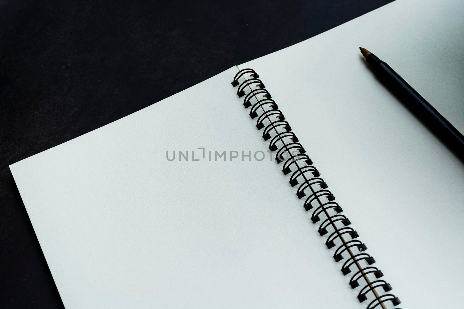 White notebook with dark background. Space for text