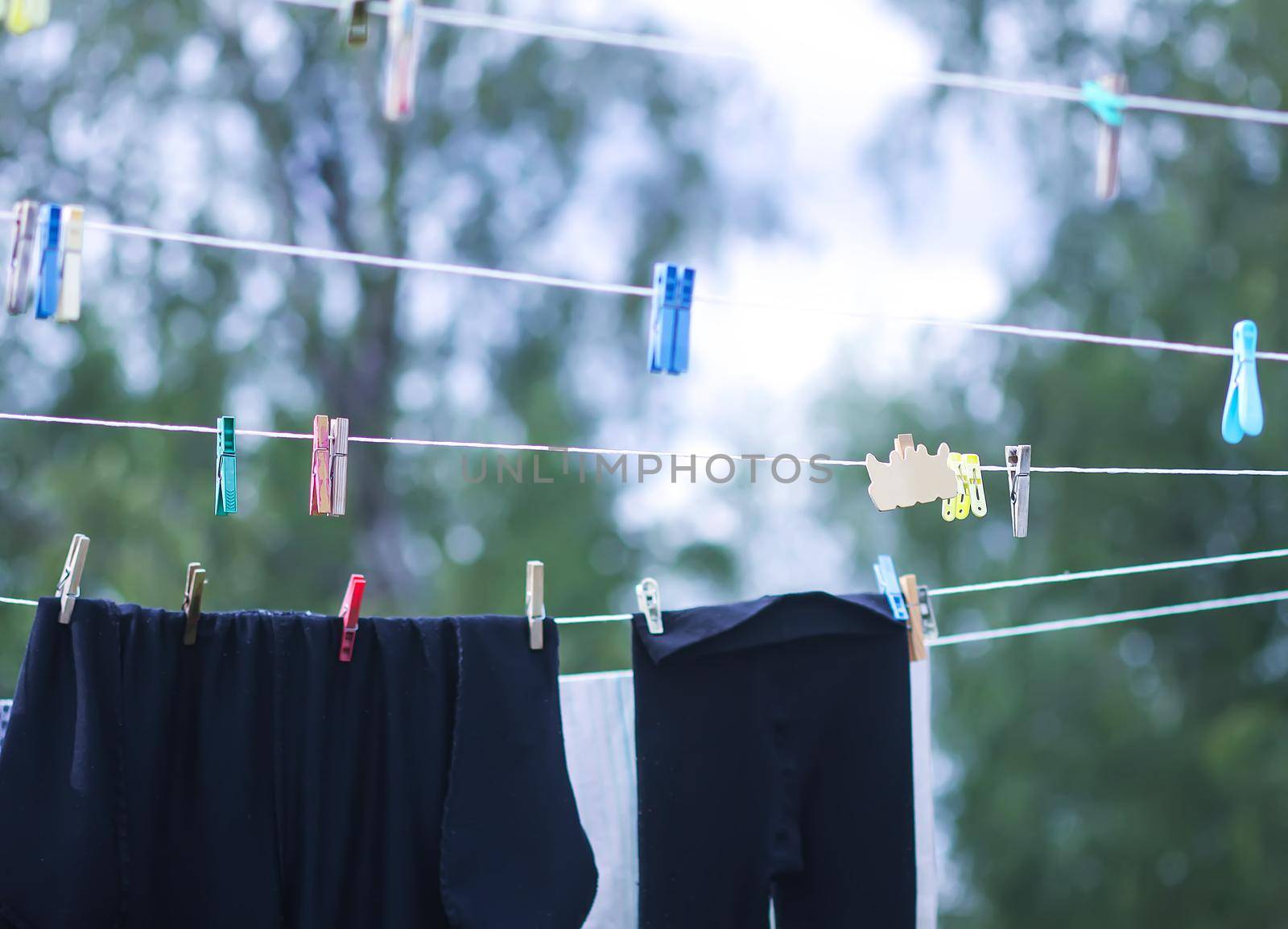 Colorful laundry hanging on the rope outdoors. The process of air drying clothes