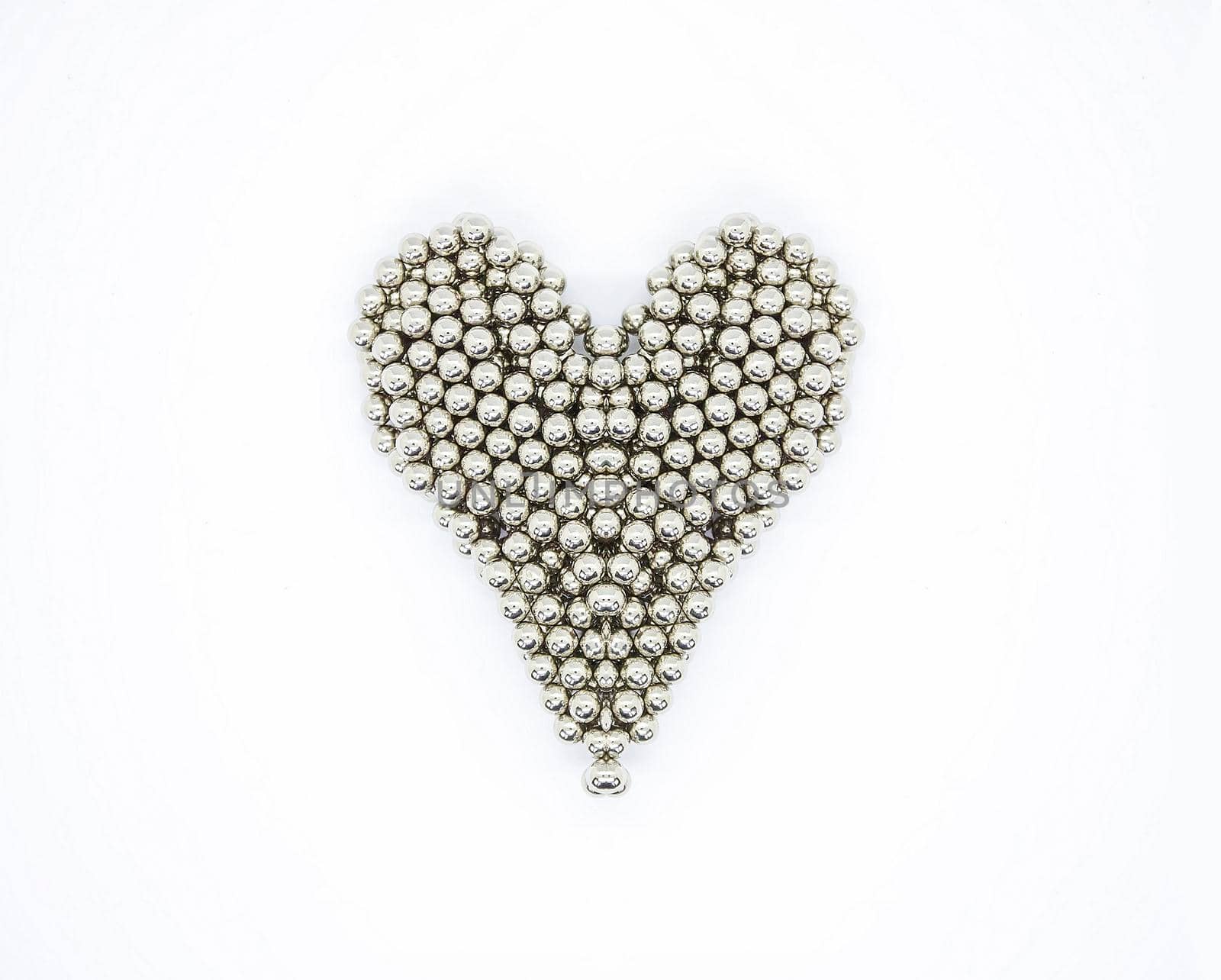 Heart shape made of metal sphere segments on white background.