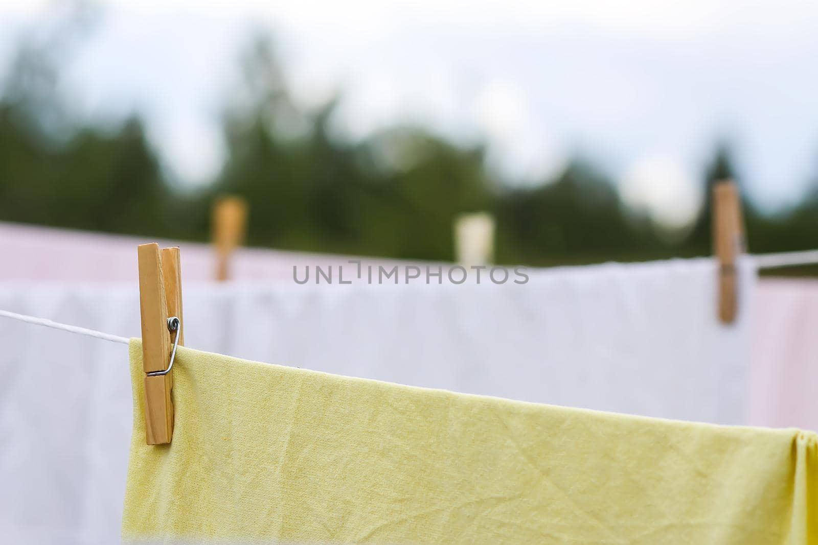 Washed colorful cotton bed sheets hanging on a clothesline outdoors