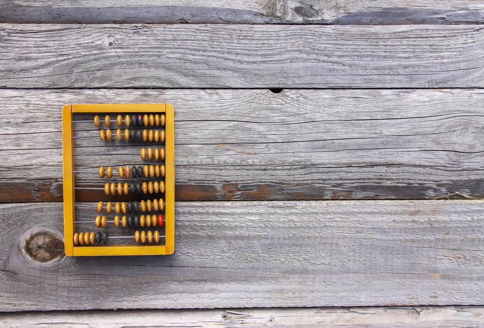 Vintage wooden abacus on old board surface.