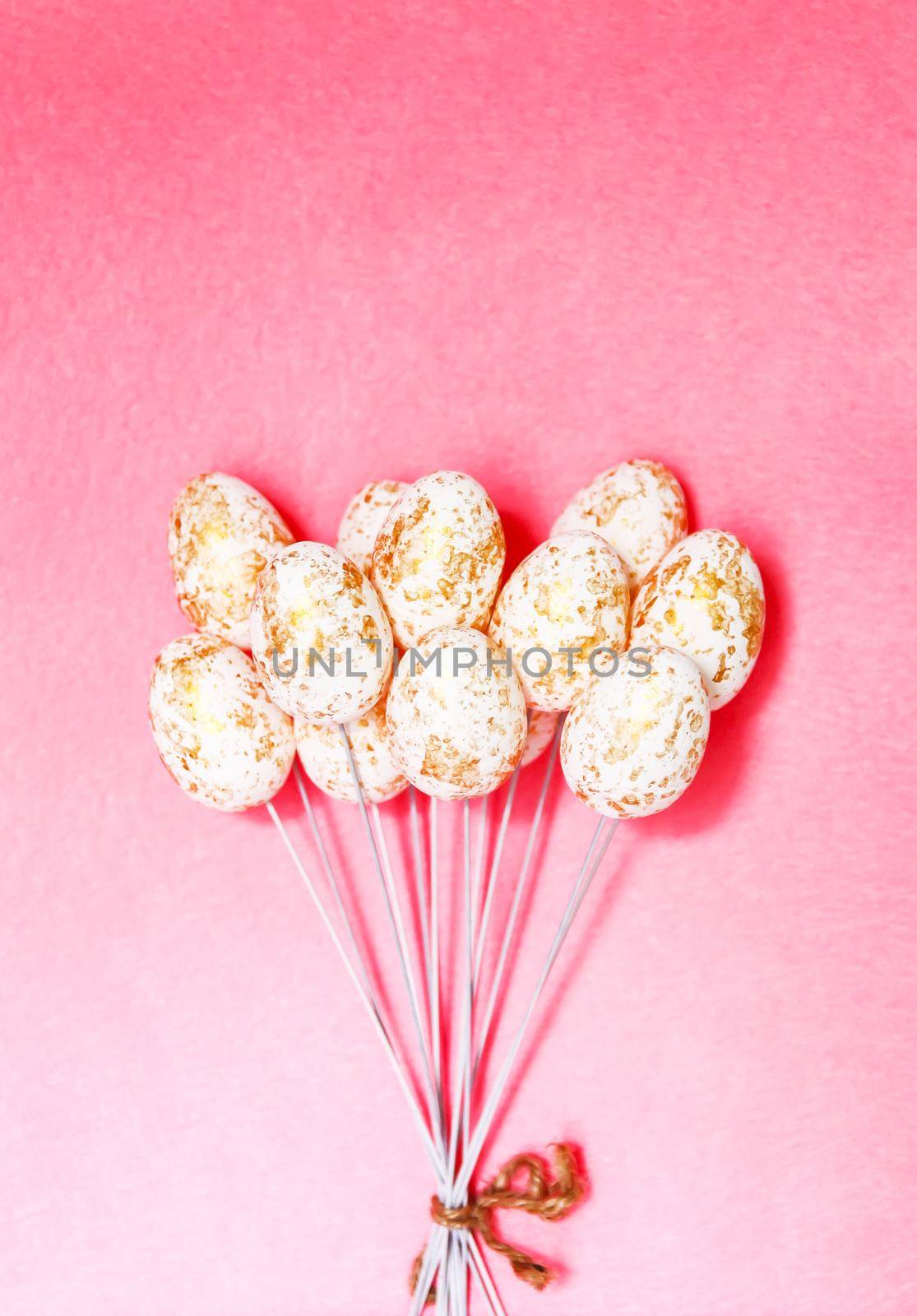 Easter vertical composition with traditional decor. Small decorative colorful eggs on pink background.