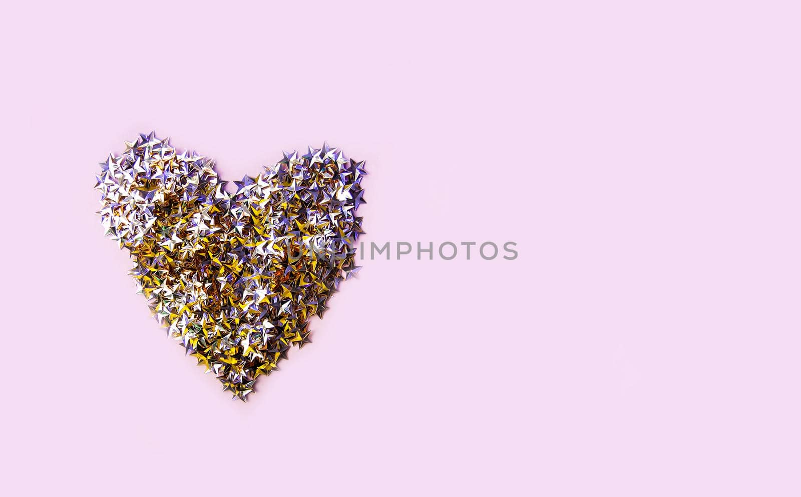 Colorful confetti heart on soft pastel background.