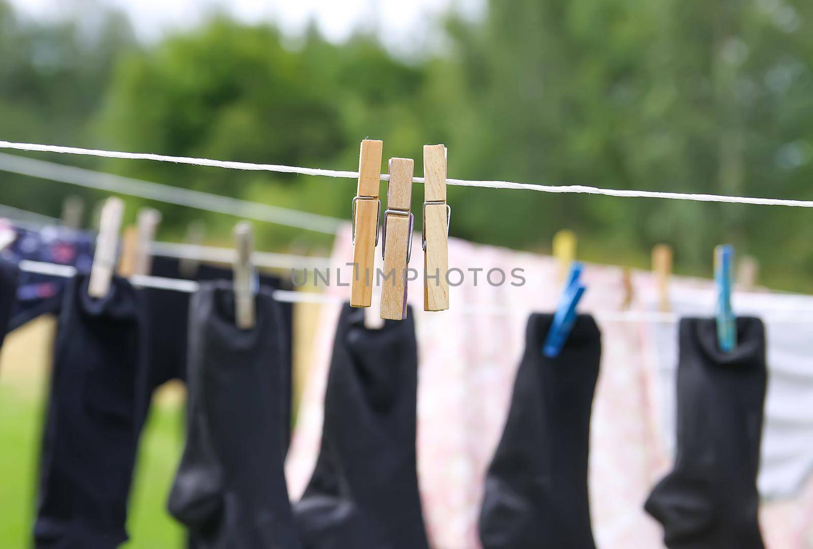Colorful laundry hanging on the rope outdoors. The process of air drying clothes
