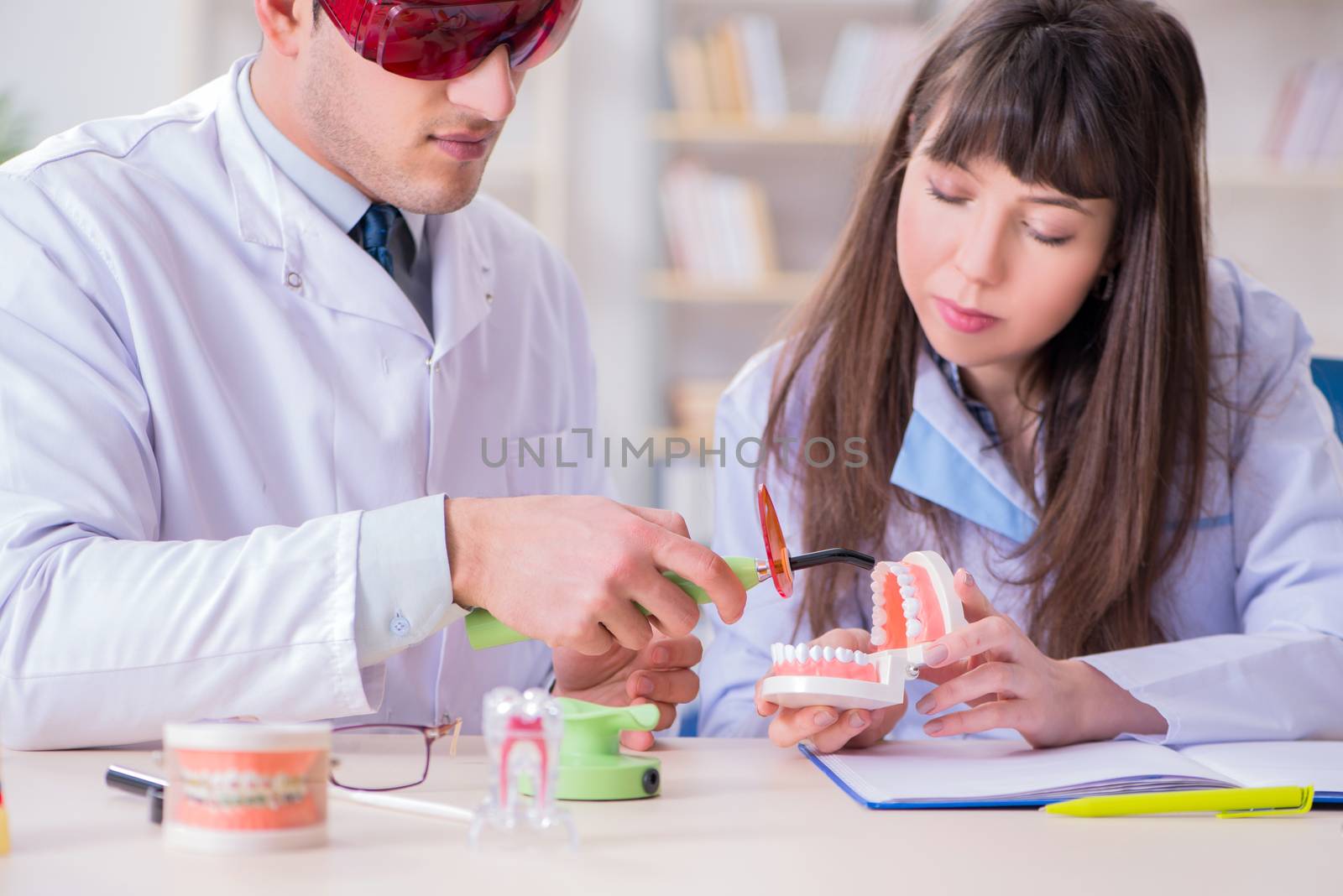 Doctor explaining to assistant how to use ultraviolet gun