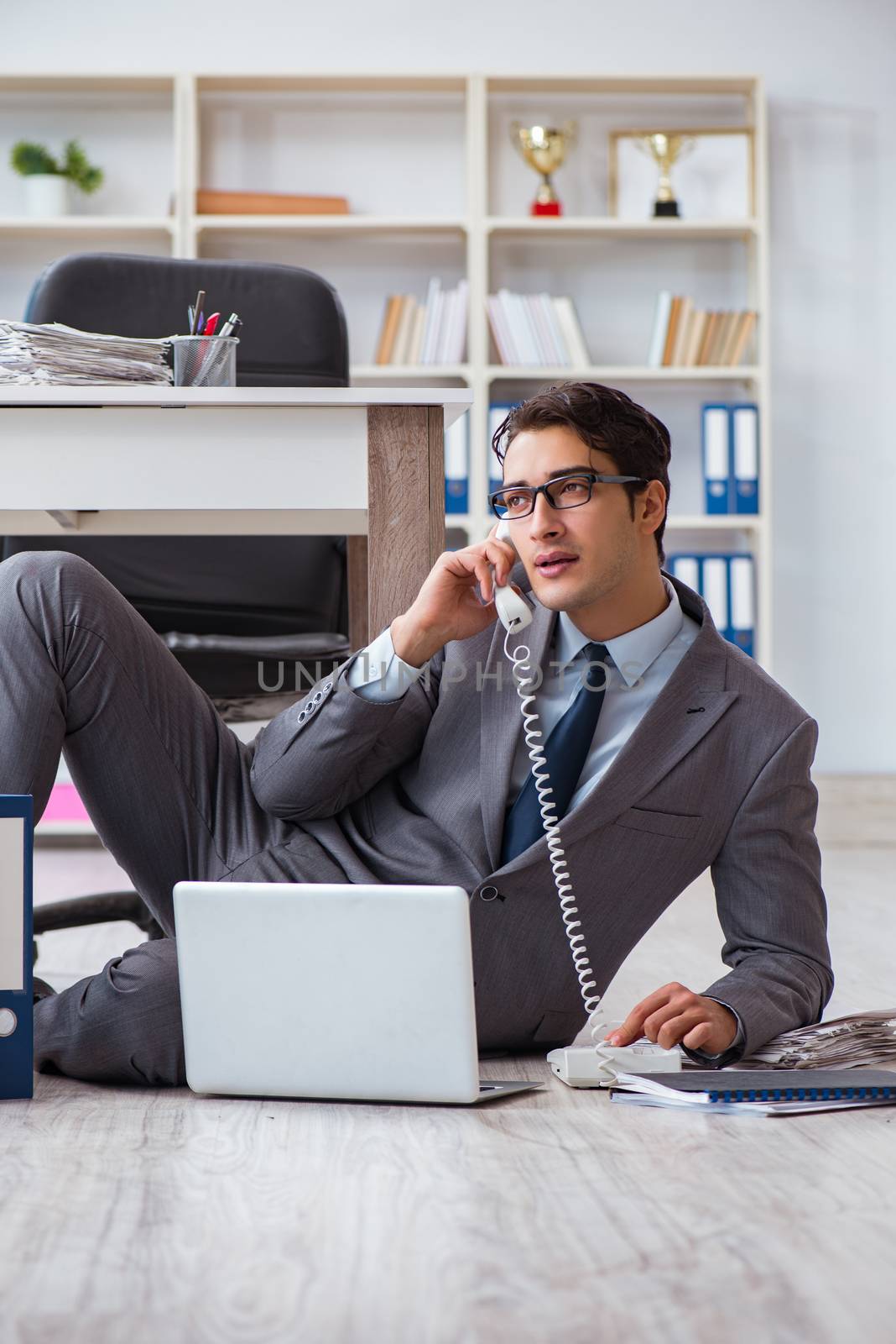 Businessman working and sitting on floor in office