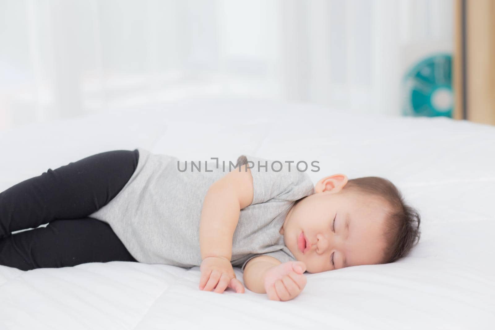 Portrait of asian little baby girl sleeping on bed in the bedroom at home, newborn napping with cozy and relax, infant innocence in bedtime, happy toddler cute, growth of child and emotion, indoors.