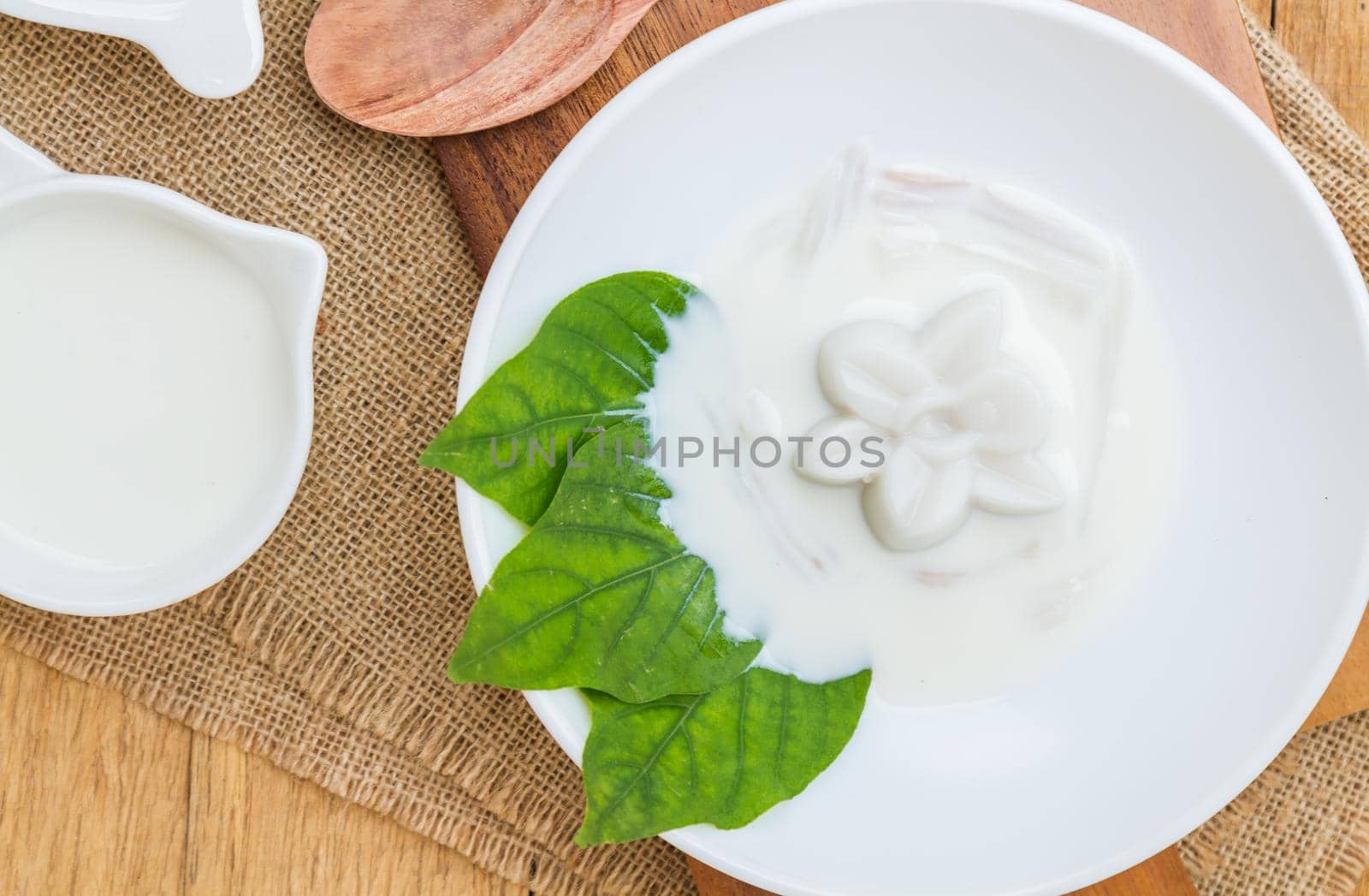 Coconut jelly coconut milk in cup on wood background local dessert thailand. Top view.