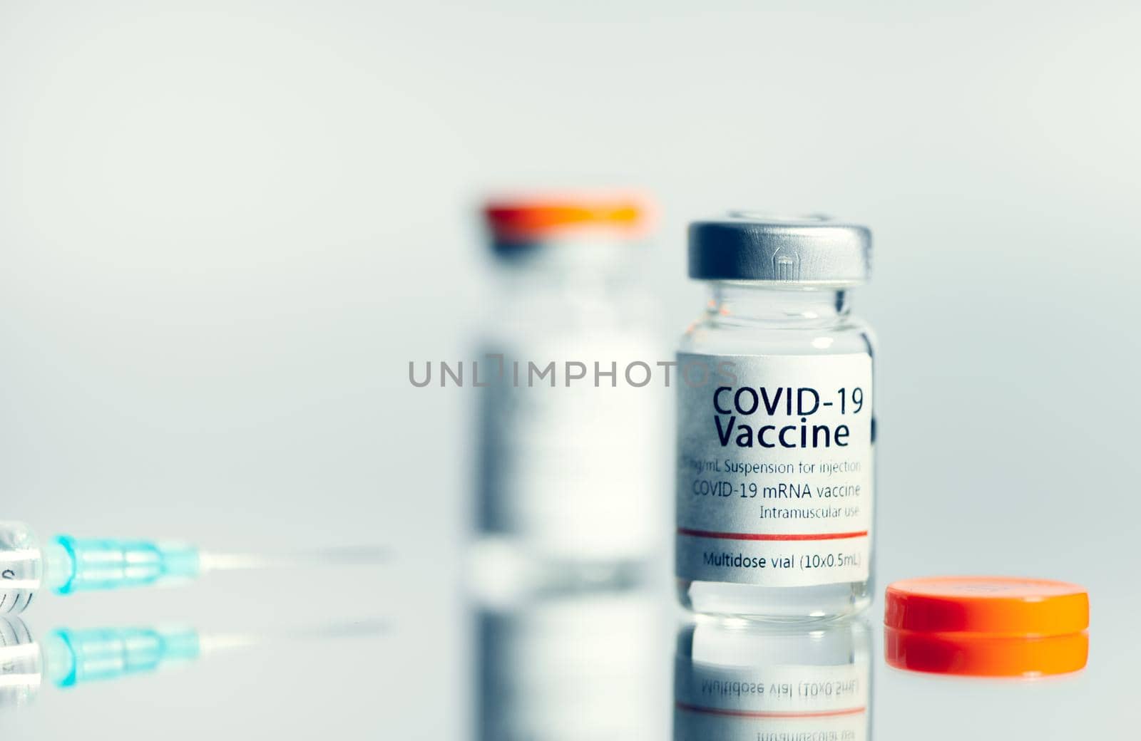 Ampoules with COVID-19 coronavirus vaccine, with a syringe for vaccination. Healthcare And Medical concept.