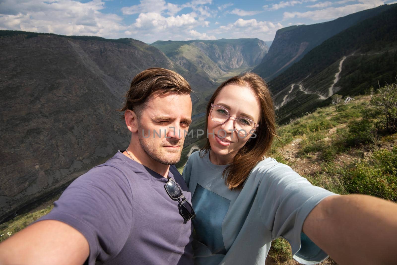 Couple selfie on the top of Altai mountain, Katu Yaryk mountain pass and the valley of the river of Chulyshman, beauty summer day landcape. Travel, leisure and freedom concept