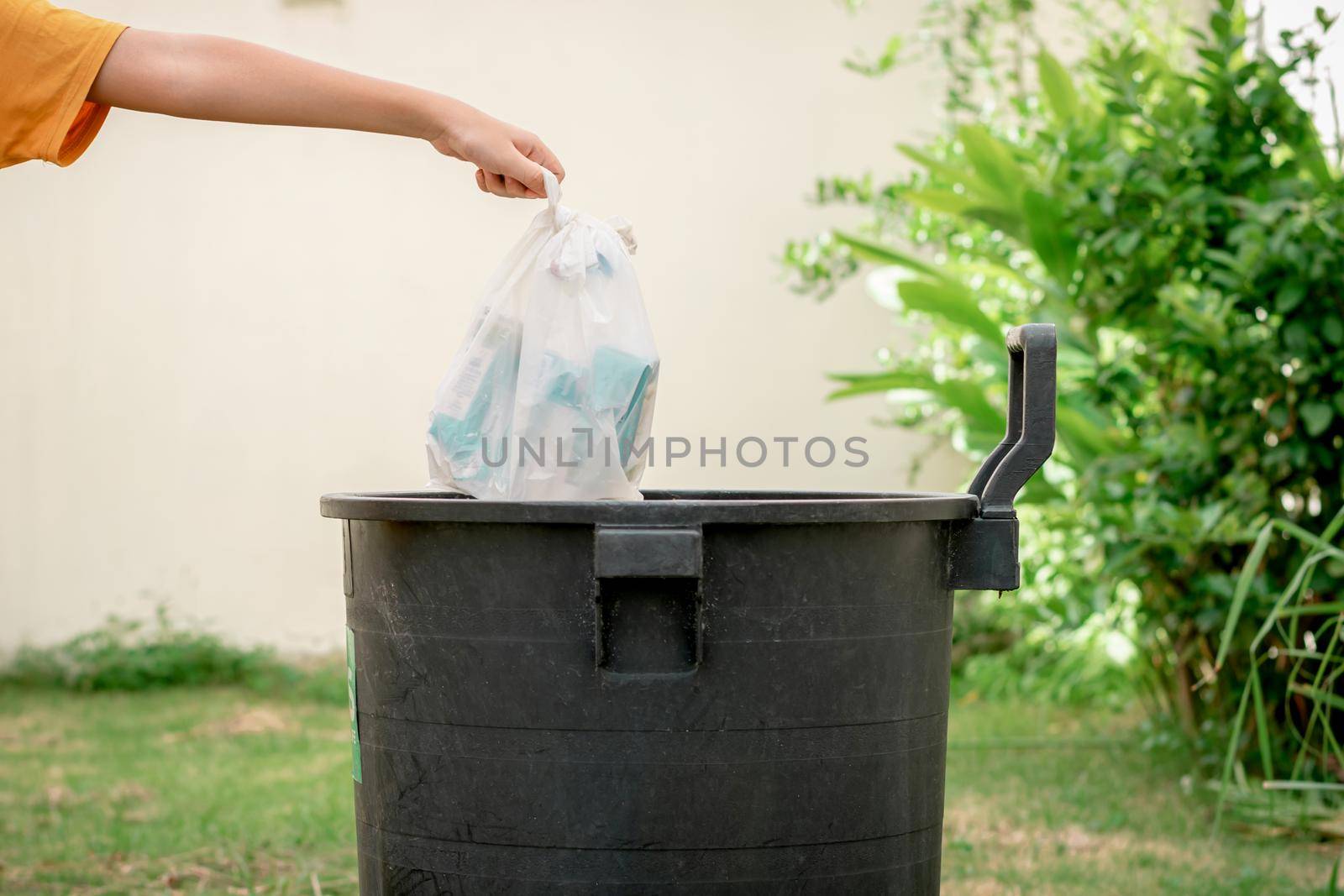 Throw trash in plastic bags into the trash in the garden. by wattanaphob