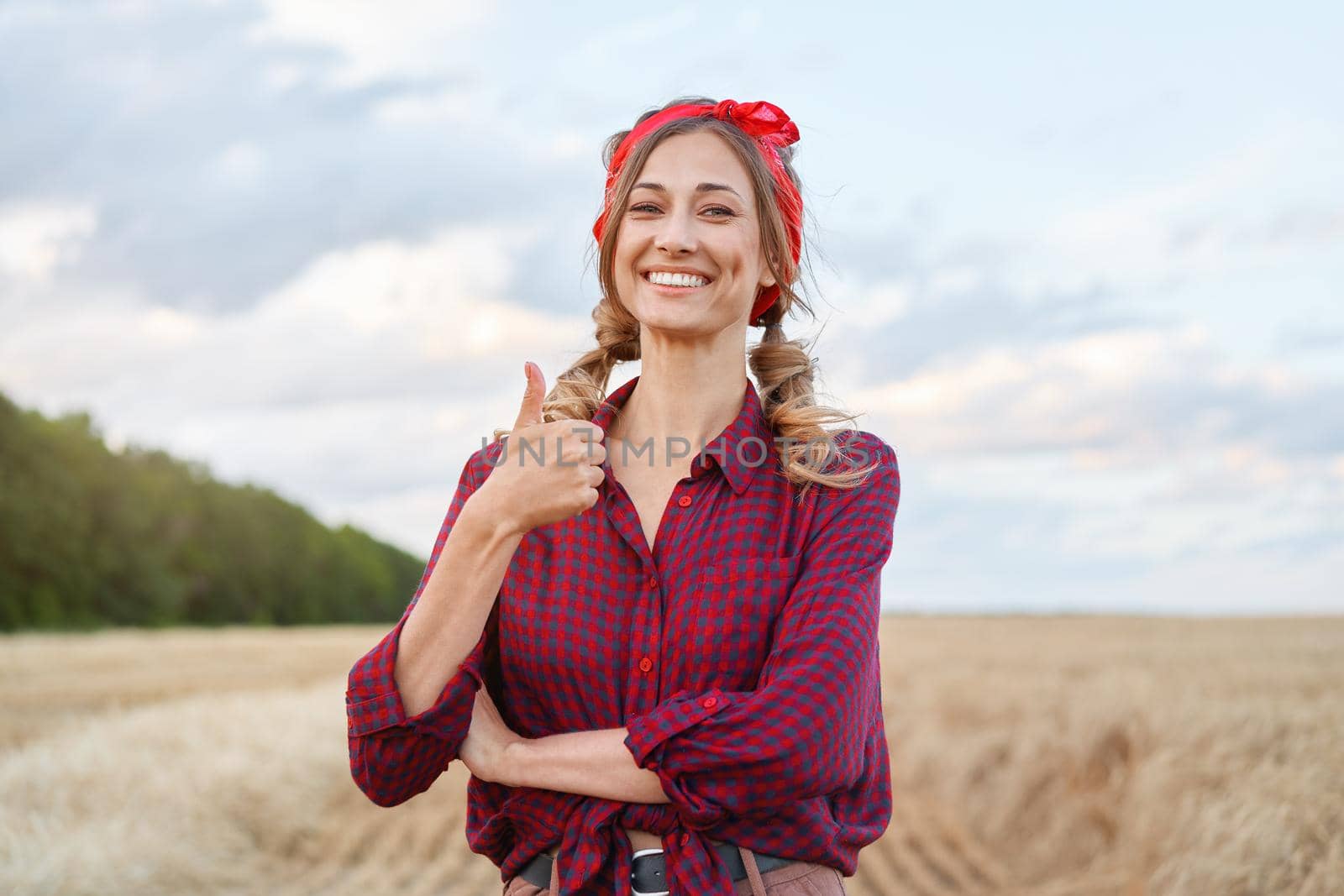 Woman farmer standing farmland smiling Female agronomist specialist farming agribusiness Happy positive caucasian worker agricultural field dressed red checkered shirt and bandana showing thumb up