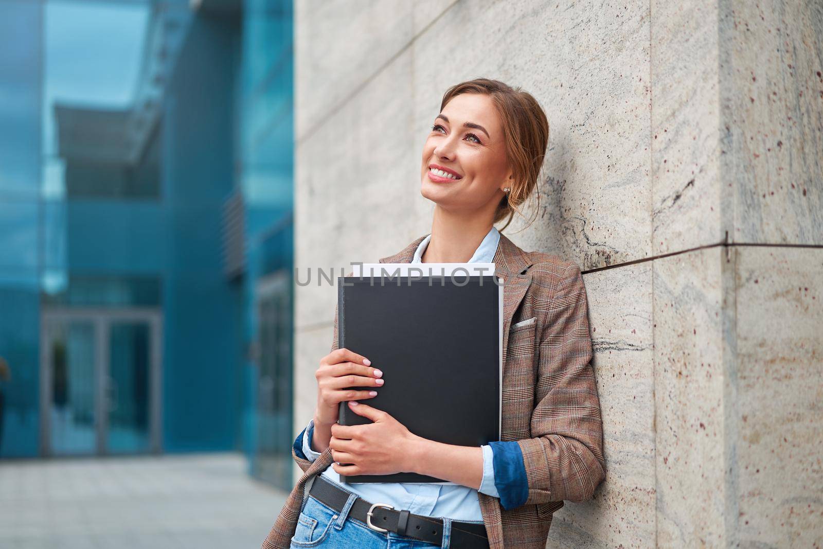 Businesswoman successful woman business person standing outdoor corporate building exterior. Pensiv caucasian confidence professional business woman middle age by andreonegin