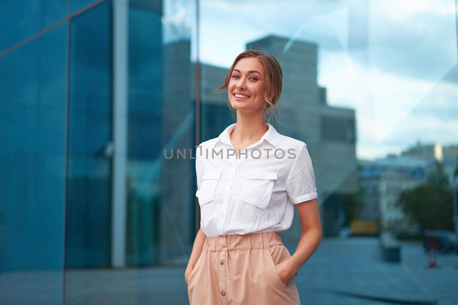 Businesswoman successful woman business person standing outdoor corporate building exterior. Smile happy caucasian confidence professional business woman middle age by andreonegin