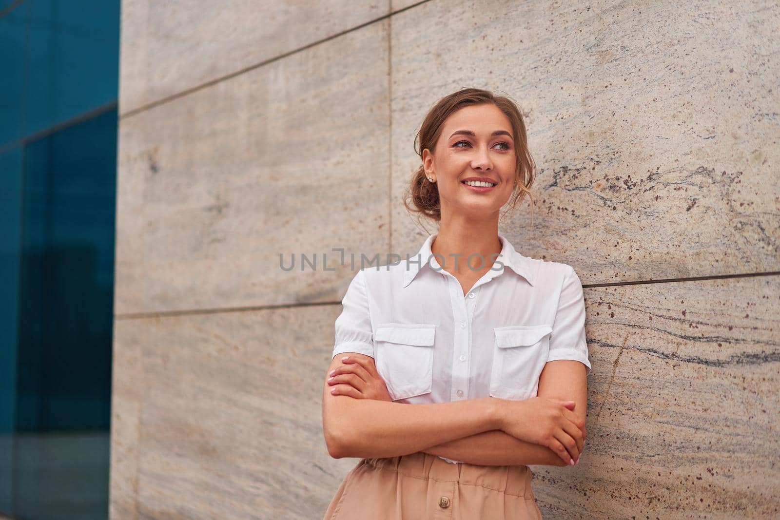 Businesswoman successful woman business person standing arms crossed outdoor corporate building exterior. Smile happy caucasian confidence professional business woman middle age by andreonegin