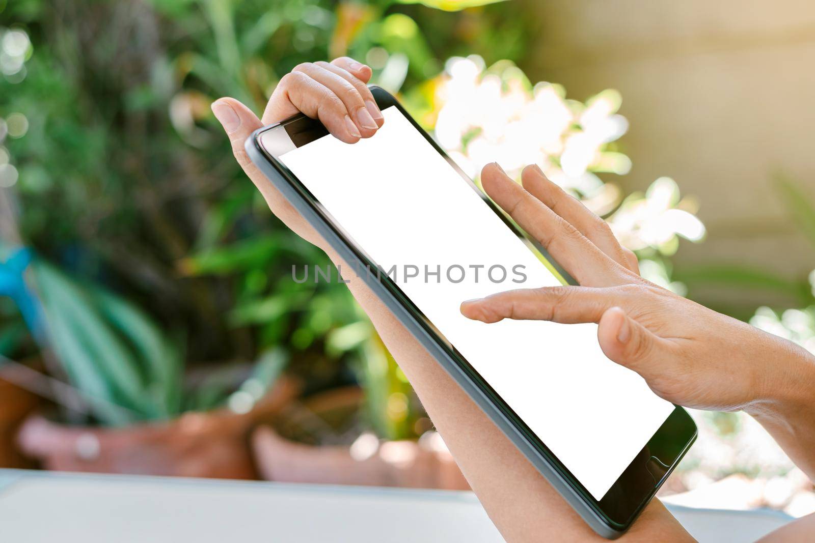 Woman's hand is touching on the white screen of the tablet, using technology and social media concepts.