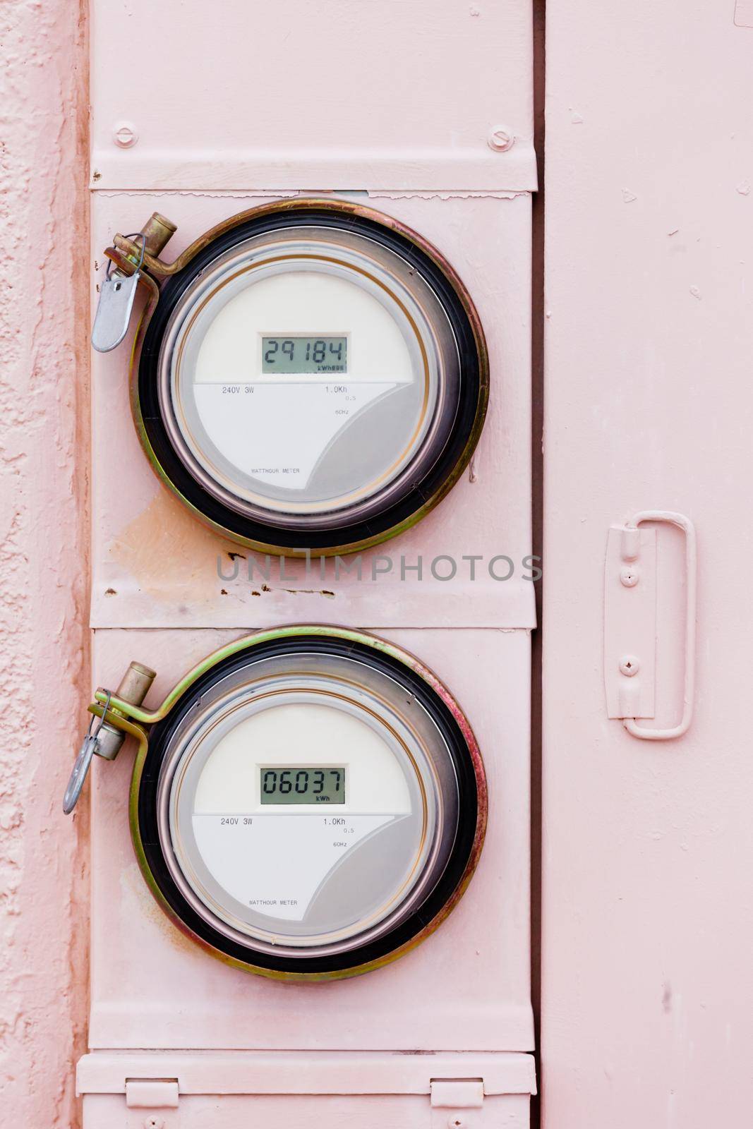 Modern smart grid residential digital power supply watthour meters on grungy pink exterior wall