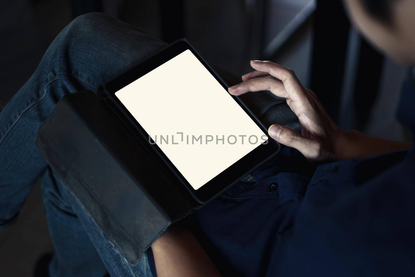 Mockup image of a black tablet with white blank screen on wooden desk.