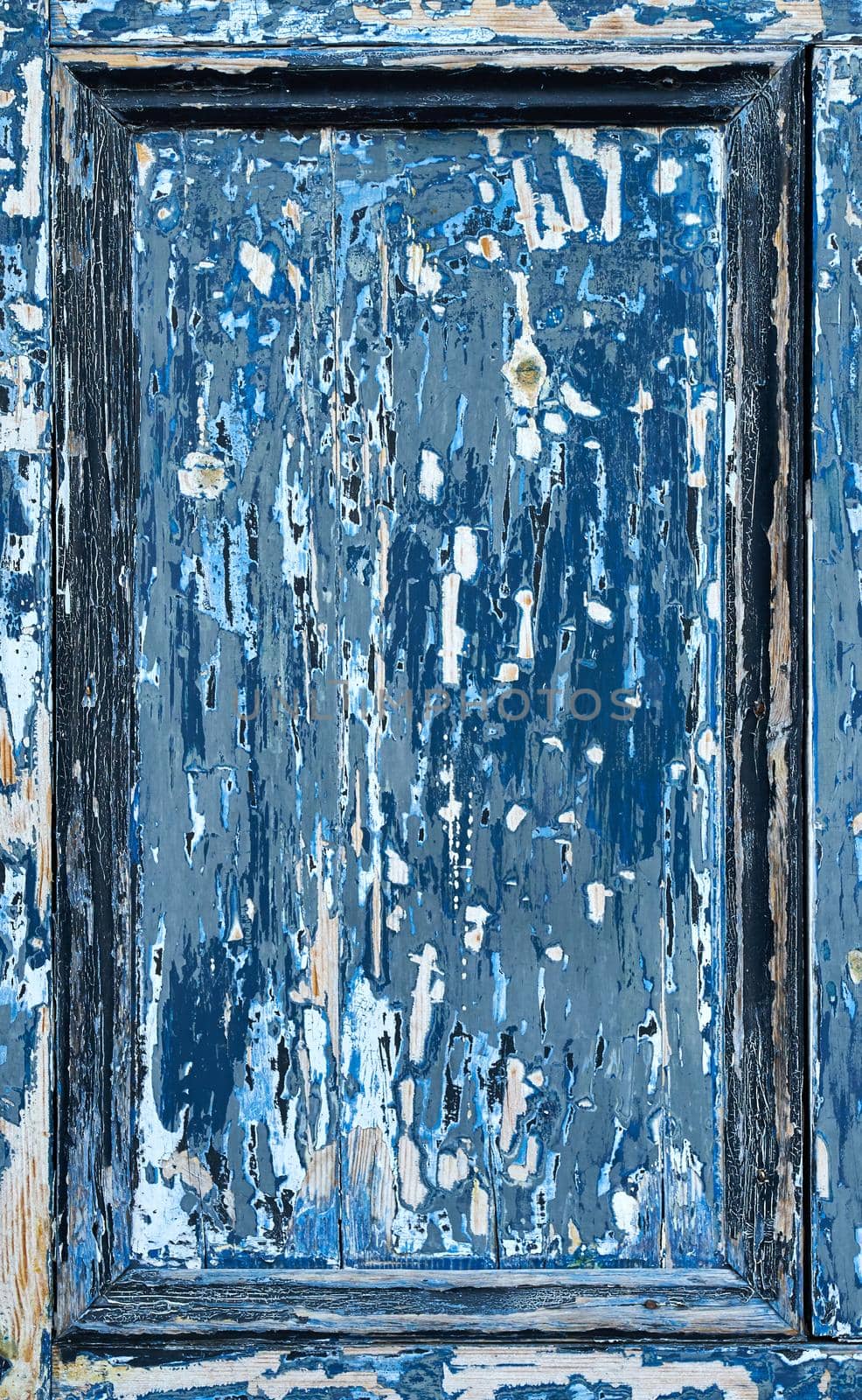 A blue door panel with very worn paint showing the wood underneath by ChrisWestPhoto