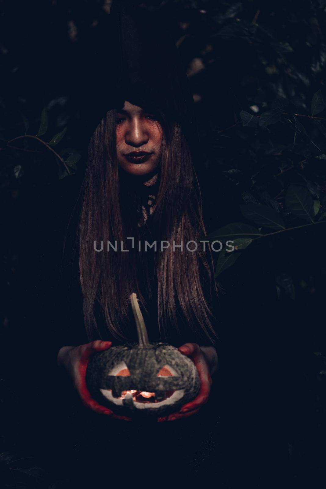 Portrait of woman ghost horror her have pumpkin on hand in forest, halloween day concept