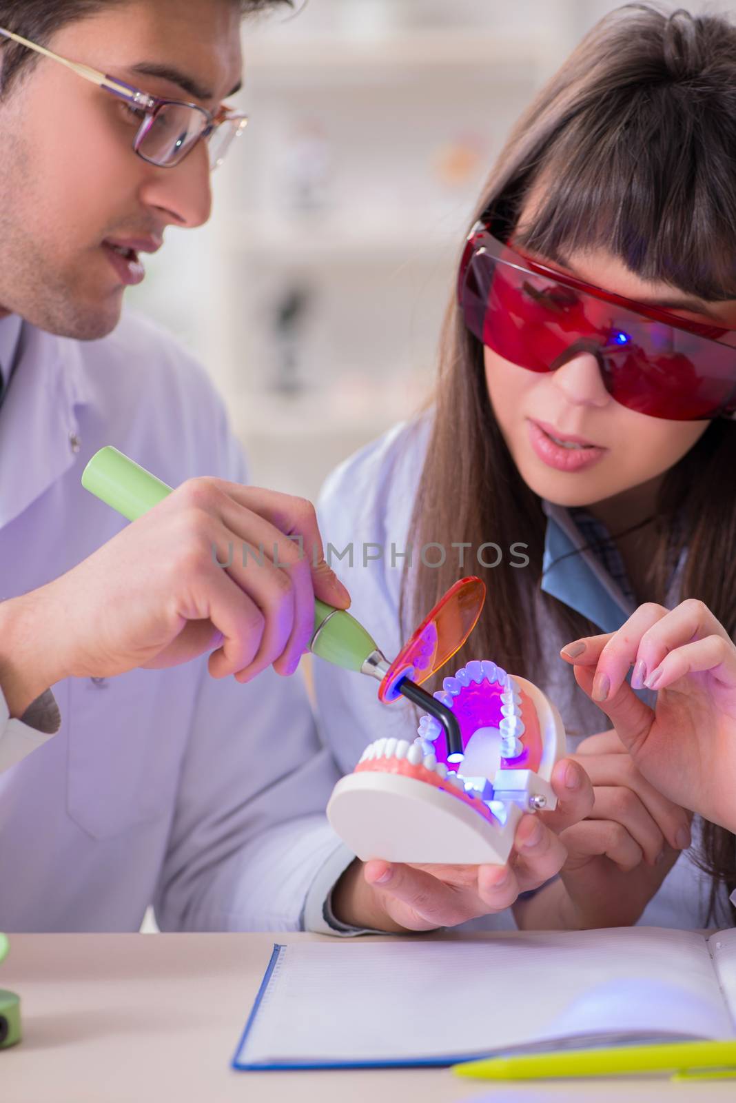 Doctor explaining to assistant how to use ultraviolet gun by Elnur