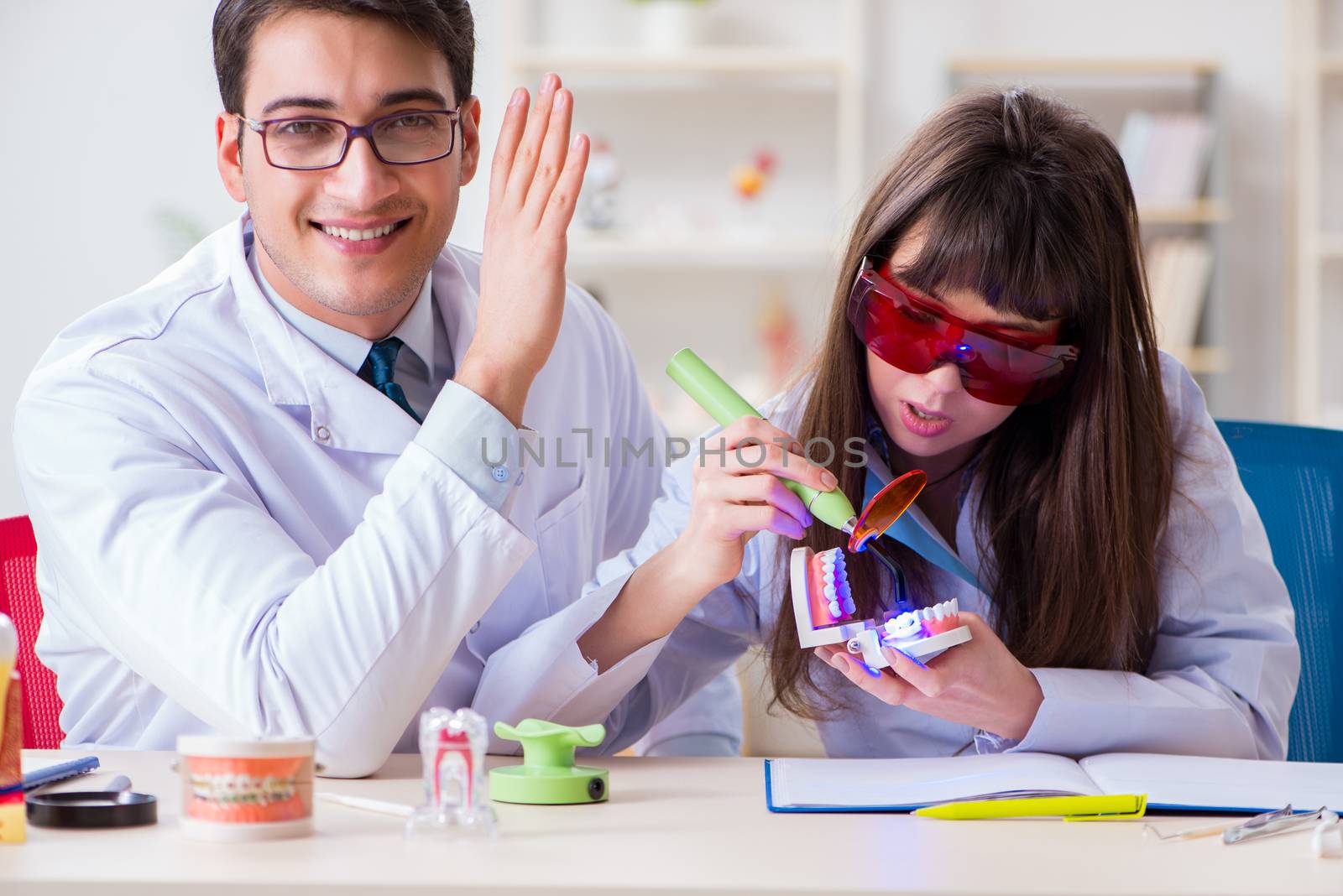 Doctor explaining to assistant how to use ultraviolet gun by Elnur
