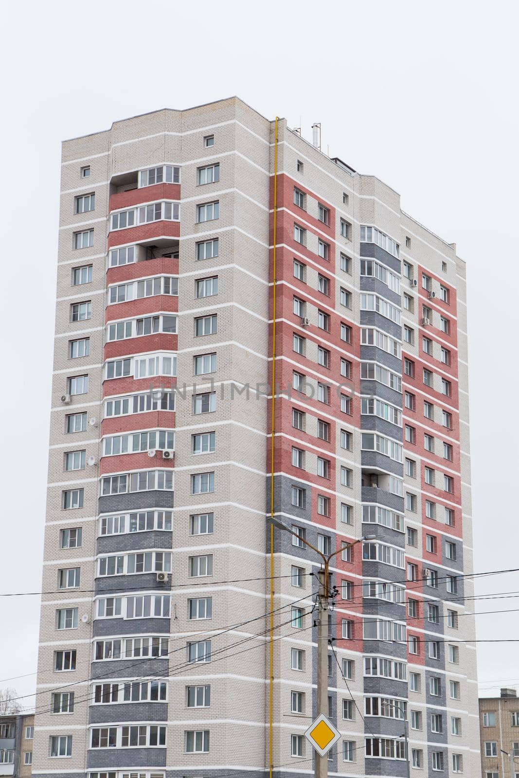 High-rise new building with gray and red balconies. Modern new buildings, building facades. Real estate and urban architecture concept.