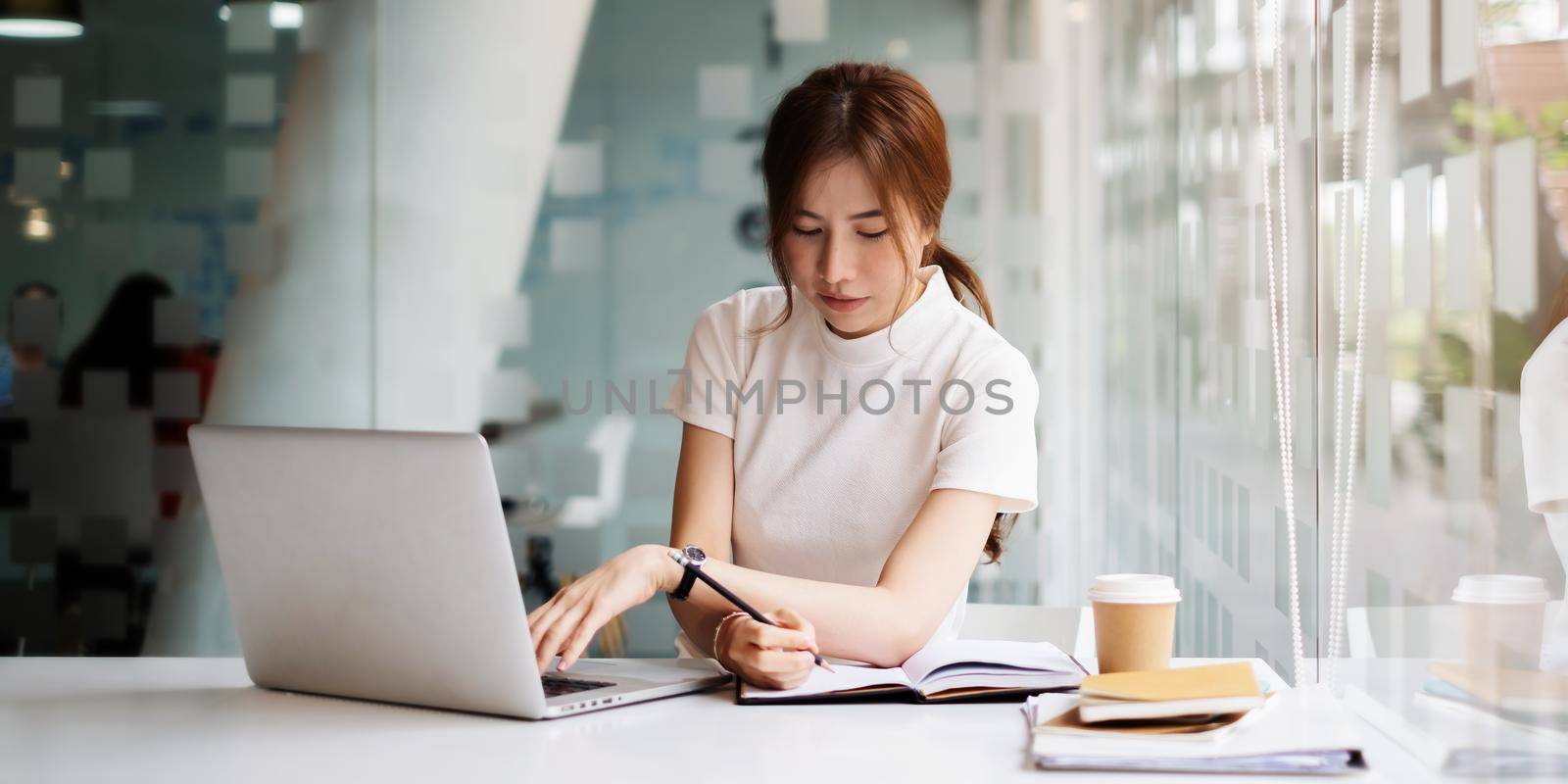 portrait of busy business woman two hand cross working and sitting at workplace while with work in office